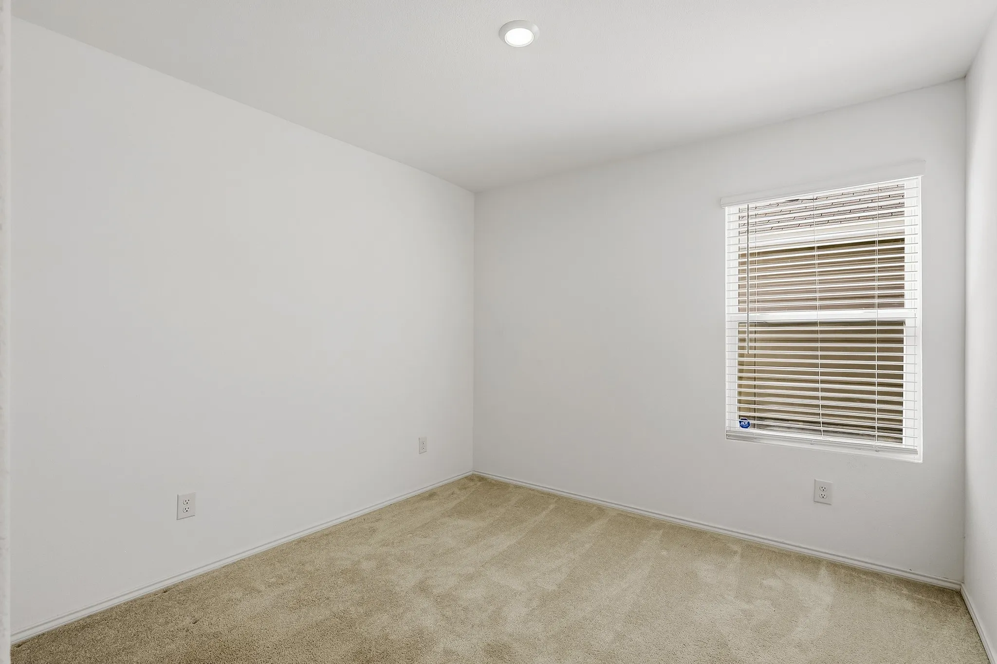Carpeted flooring, recessed ceiling light, window with blinds, white walls, and white trim