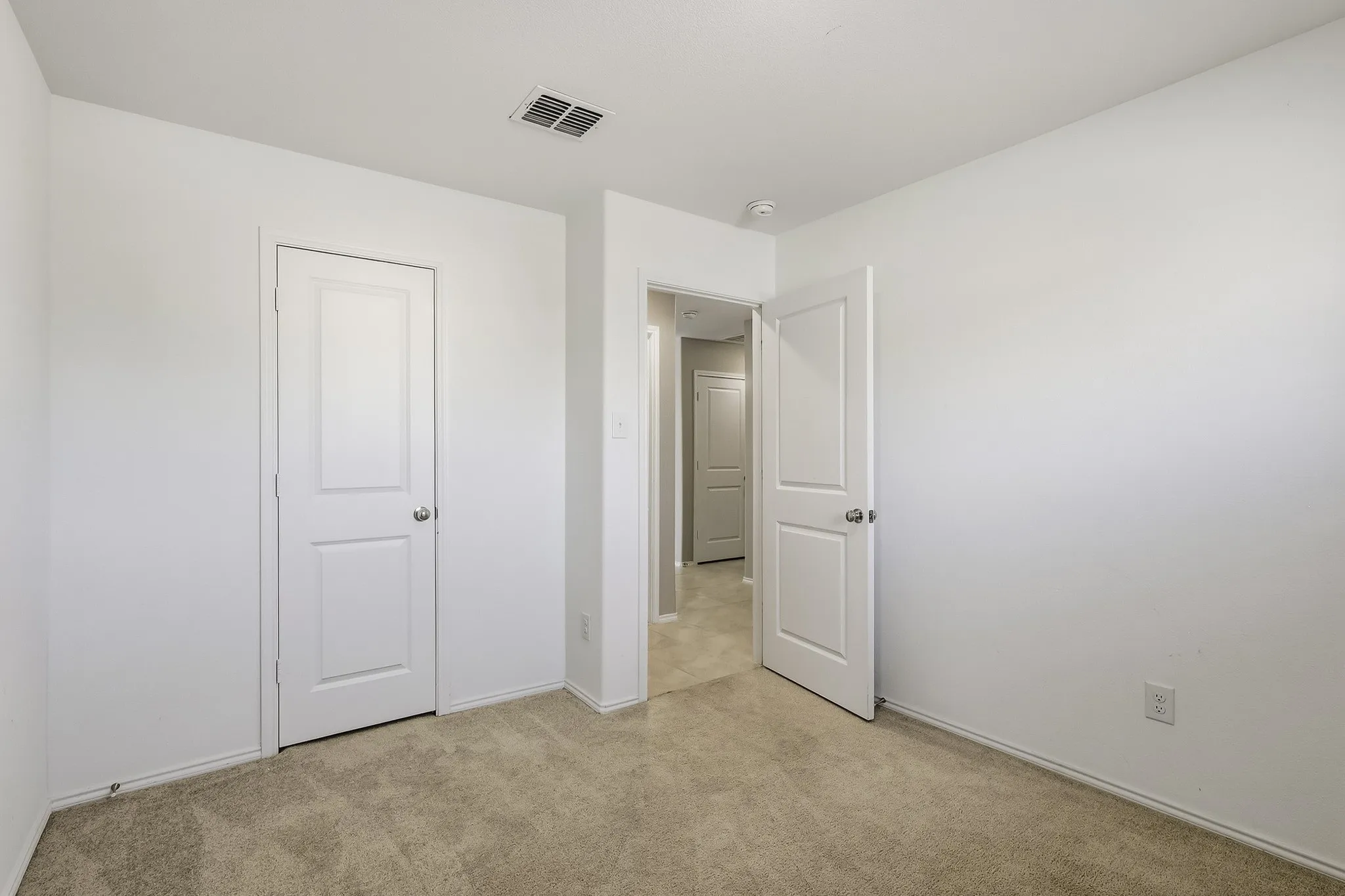 Neutral wall color, two-panel interior doors, light-toned carpeting
