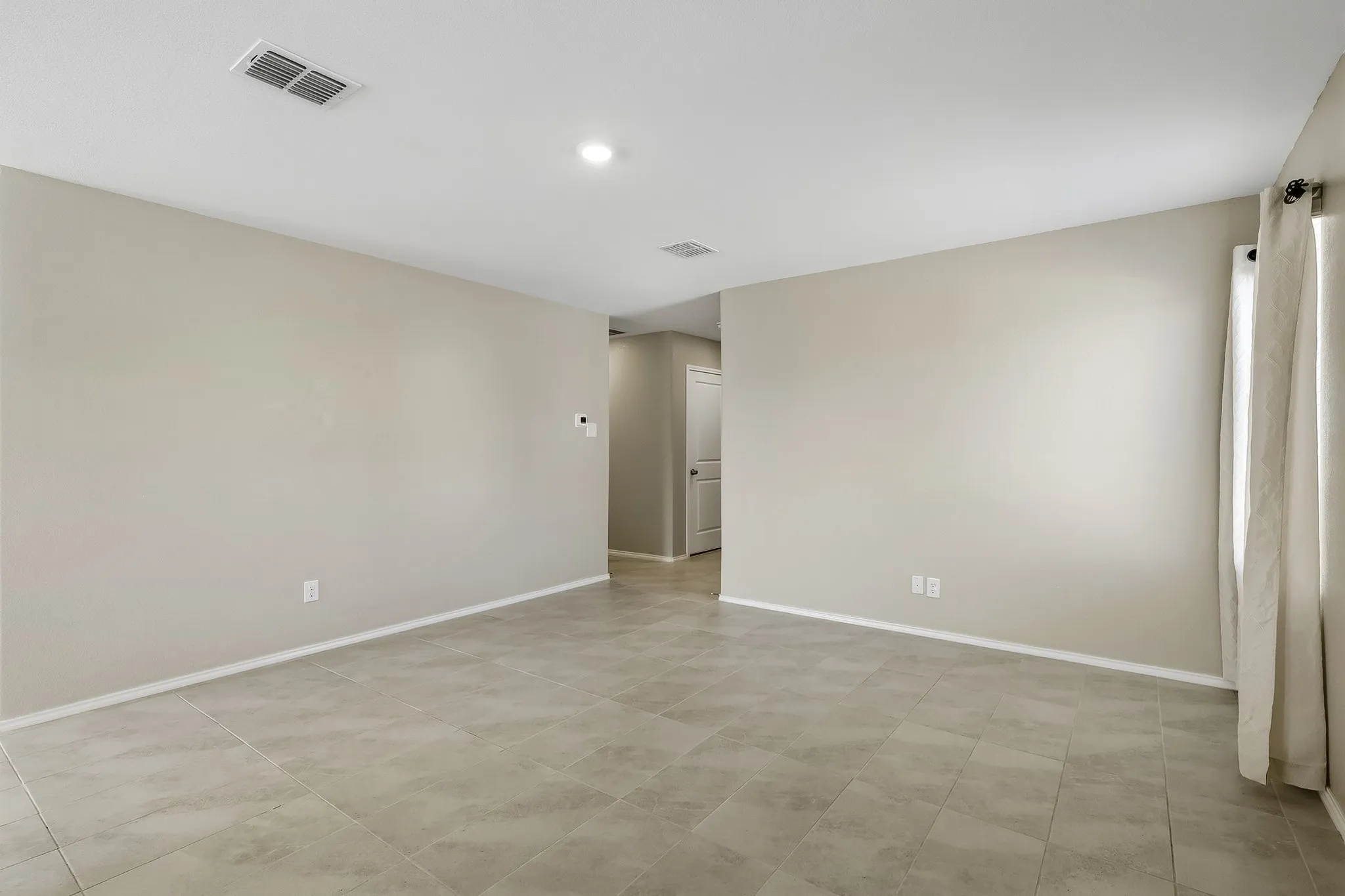 Recessed lighting, light-toned walls, and tiled flooring