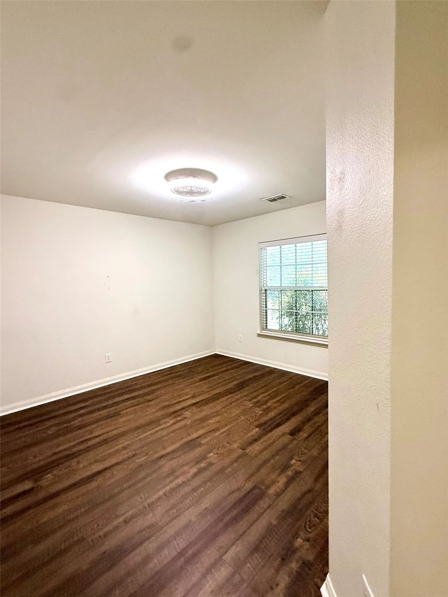 Bedroom 2 Wood-finish flooring with white trim and a flush-mount ceiling light