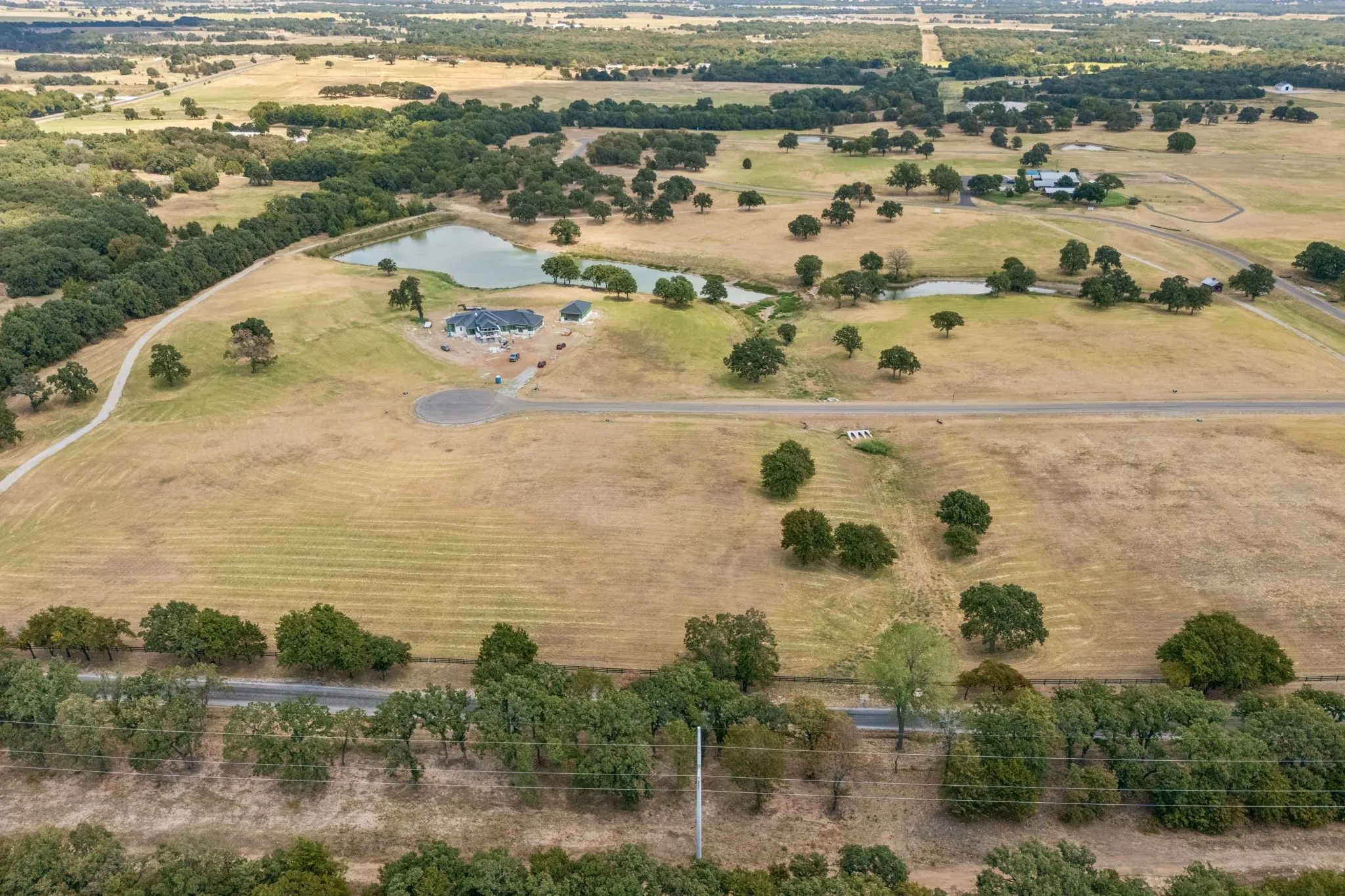 Expansive property featuring multiple ponds, mature trees, and a private driveway