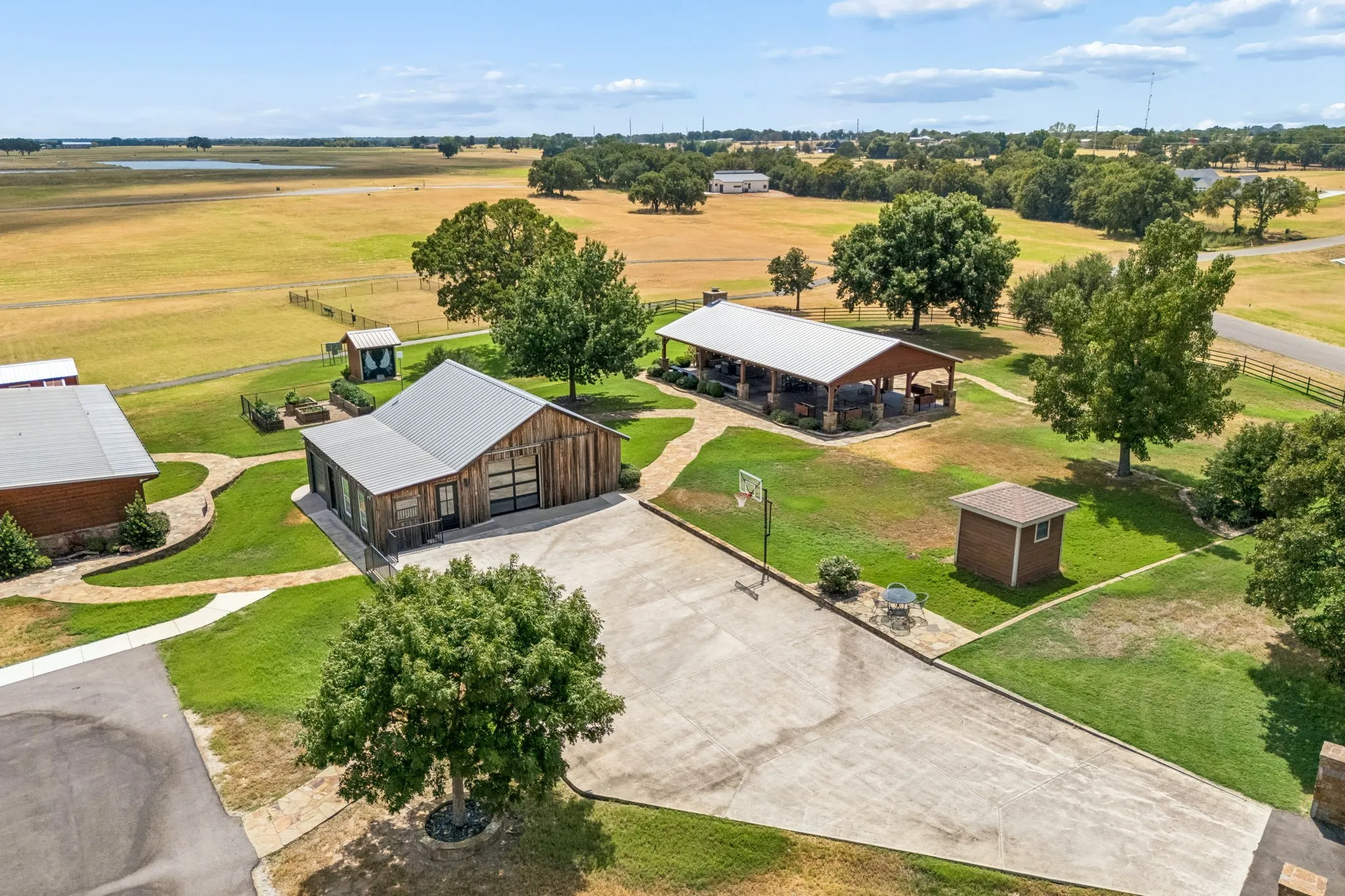 Expansive grounds featuring multiple structures, a large covered patio, and a basketball goal
