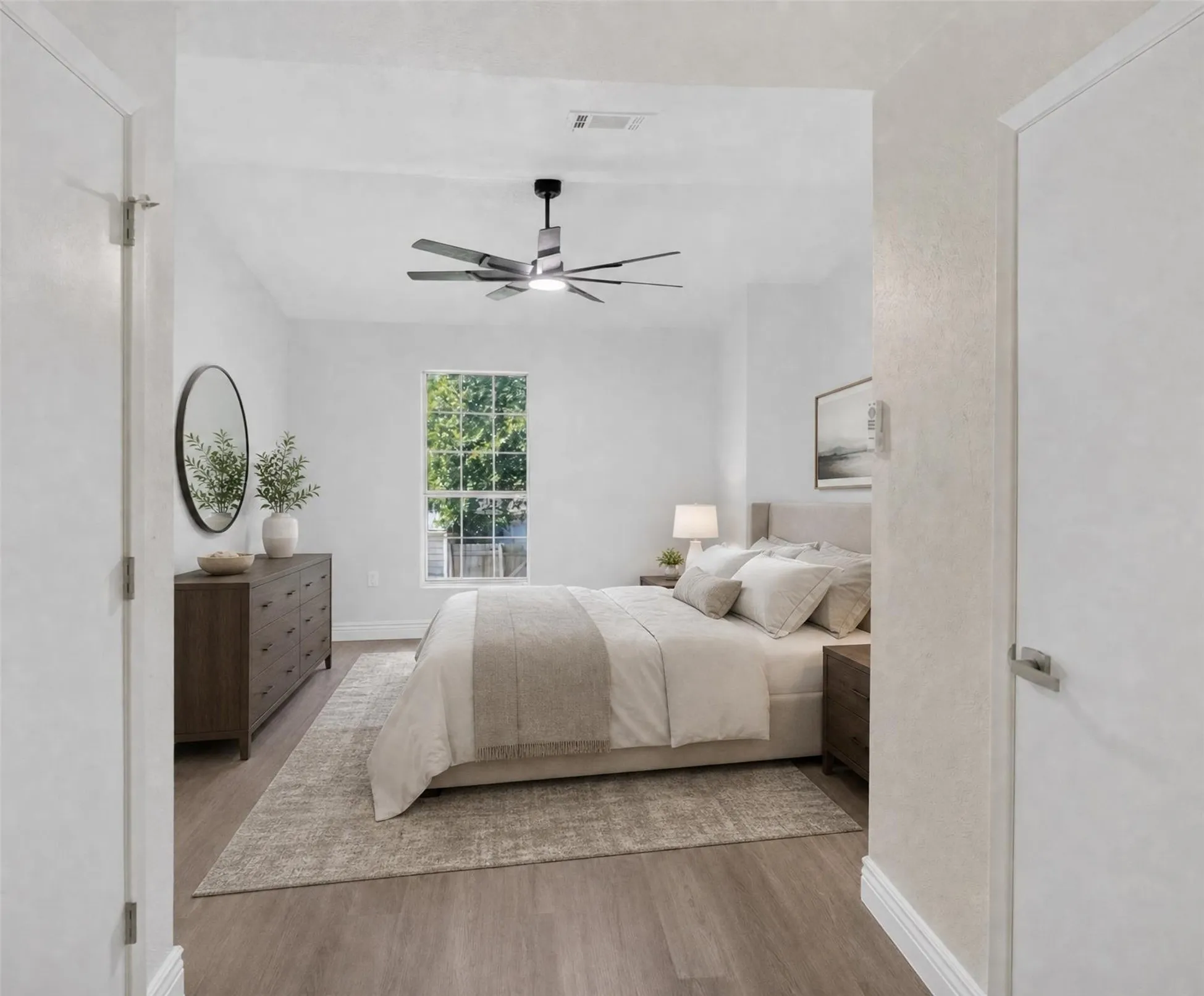 Spacious room with wood-finish flooring and white walls