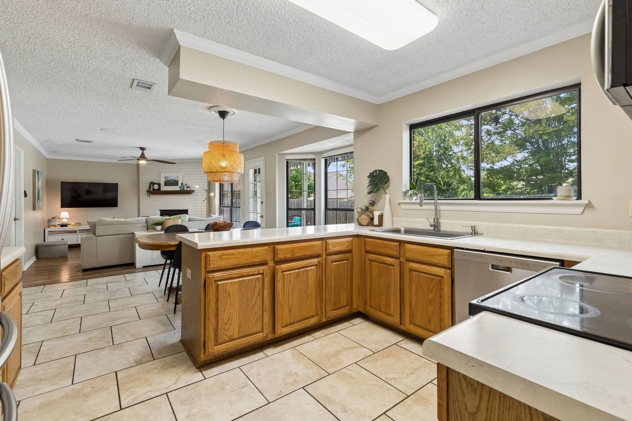 Spacious Kitchen with Wraparound Countertops, Ample Cabinet Storage and Large Window over the Sink