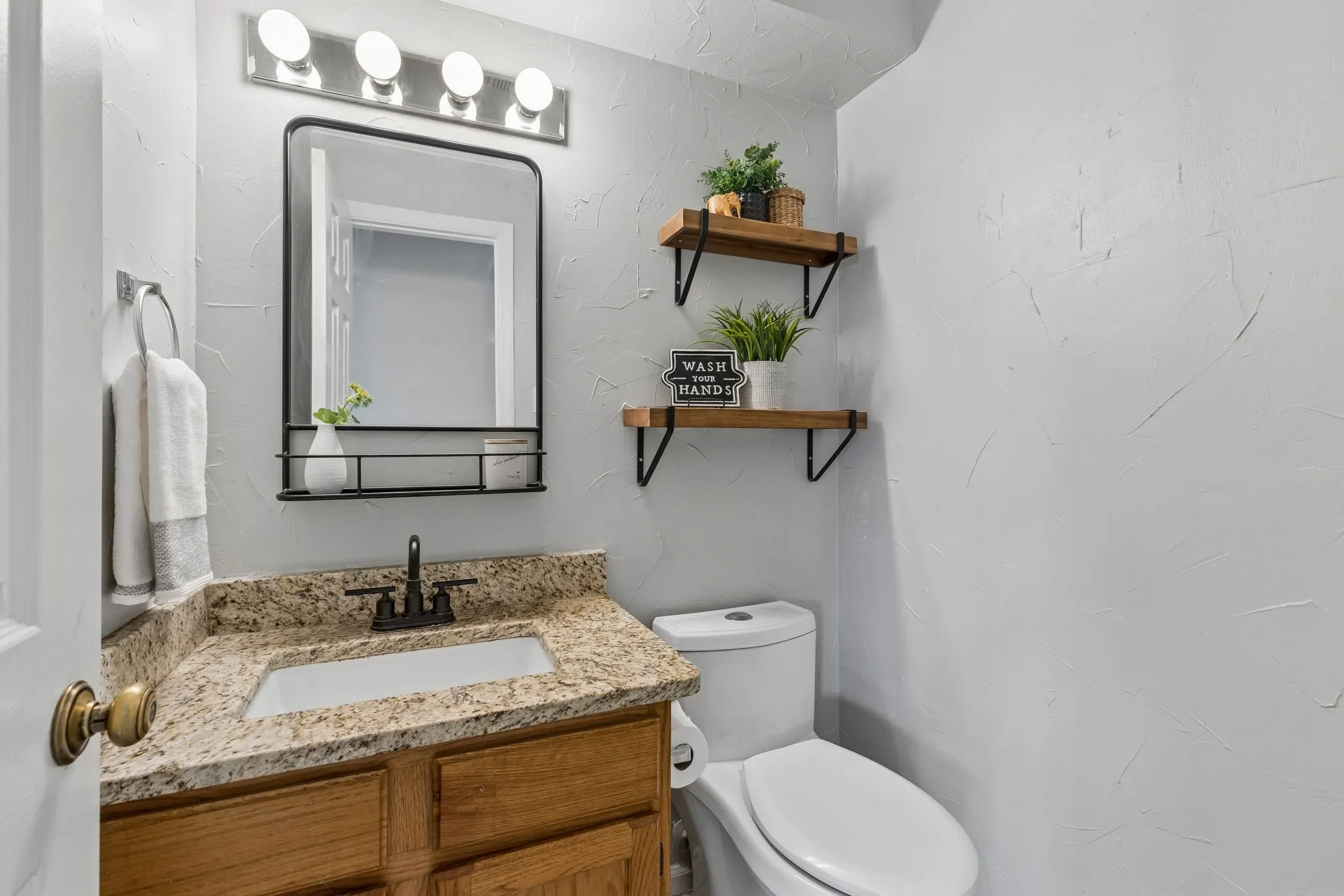 Half Bath with Granite Countertop, Framed Mirror and Decorative Open Shelving