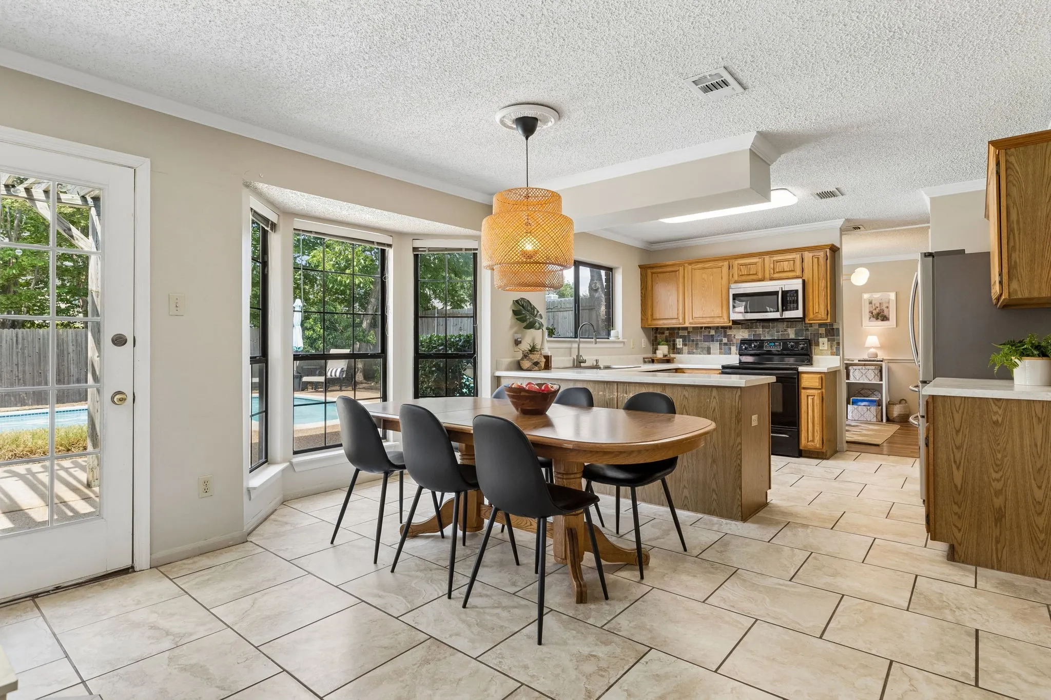 Bright Breakfast Area with Bay Windows, Tile Flooring and Convenient Backyard Access