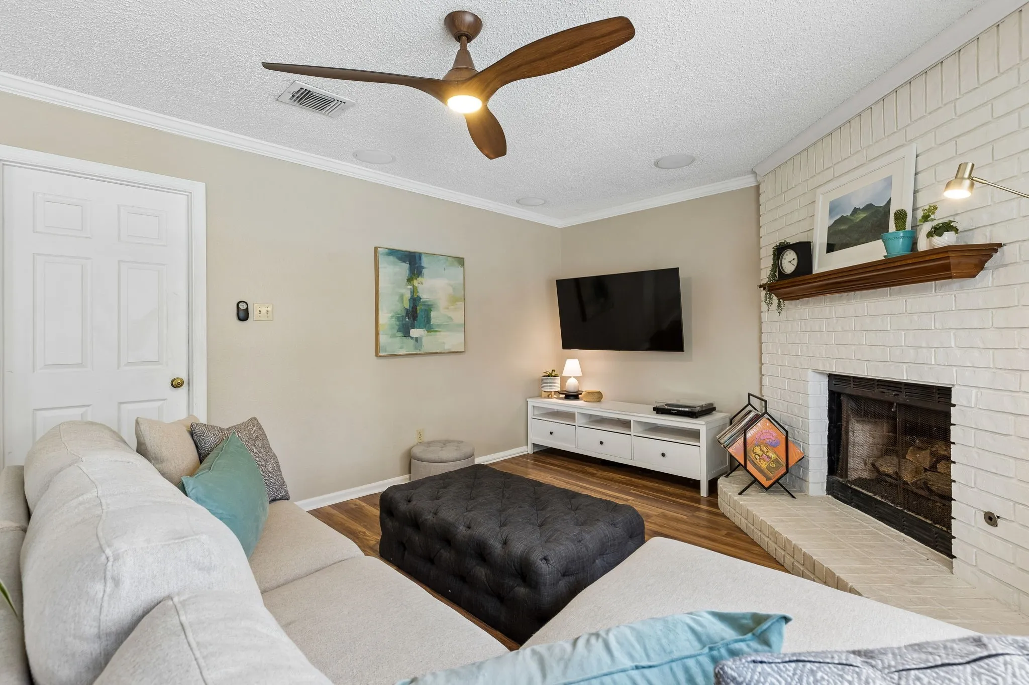 Living Room with Painted Brick Fireplace, Modern Ceiling Fan and Comfortable Seating Area