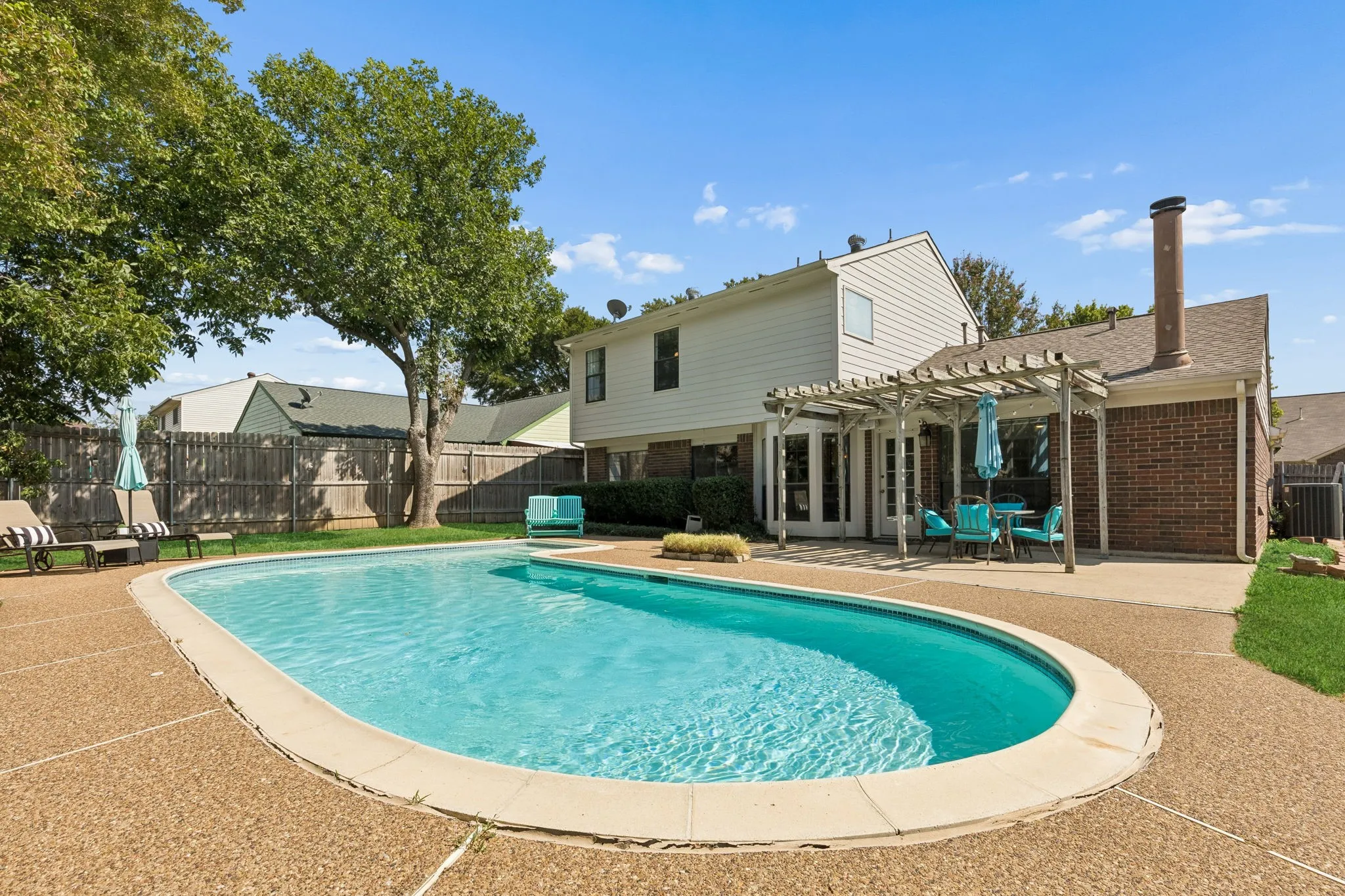 Sparkling In-Ground Pool with Spacious Surrounding Patio for Outdoor Enjoyment