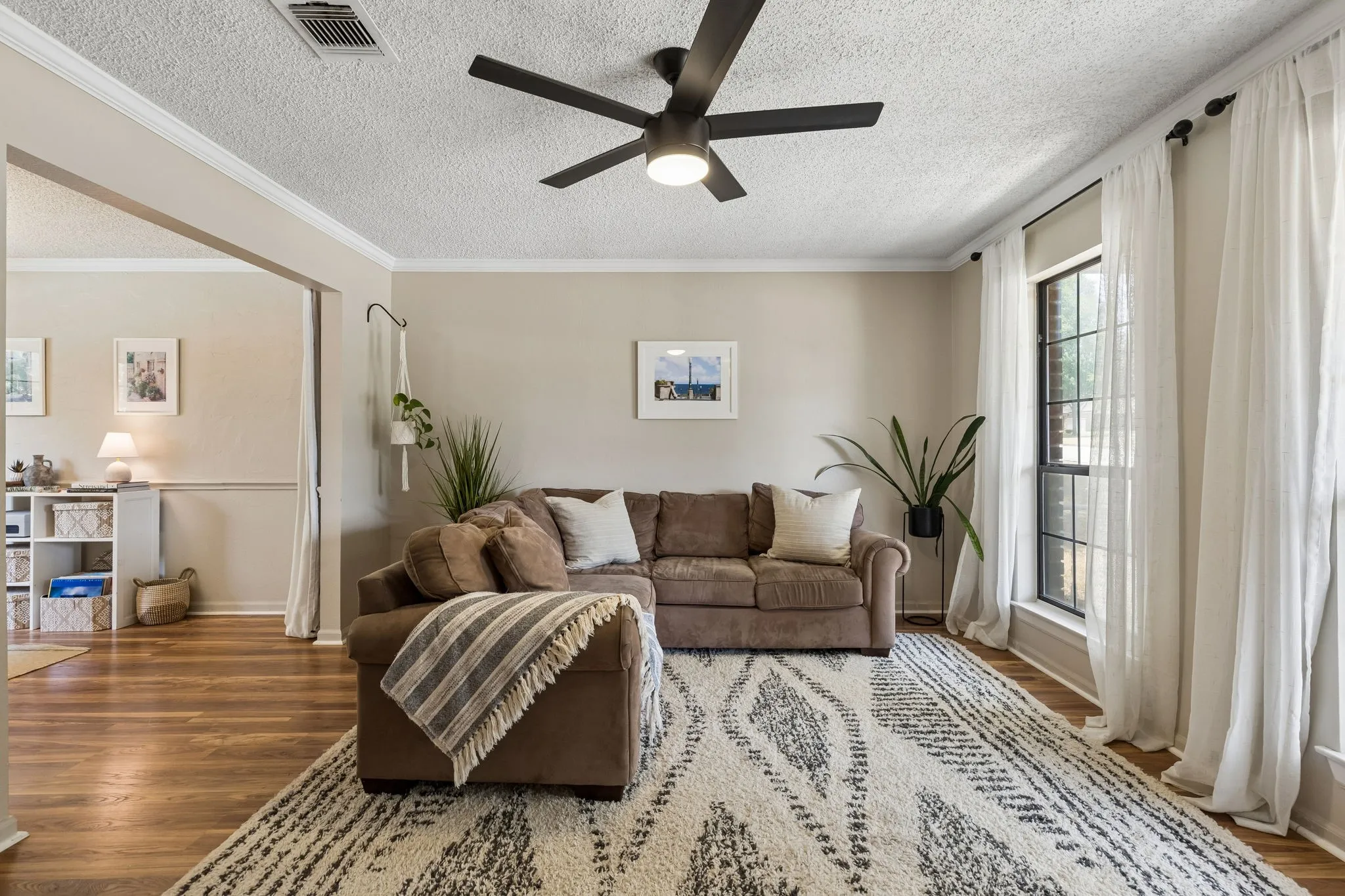 Spacious Living Room with Wood-Look Flooring, Large Windows and Abundant Natural Light