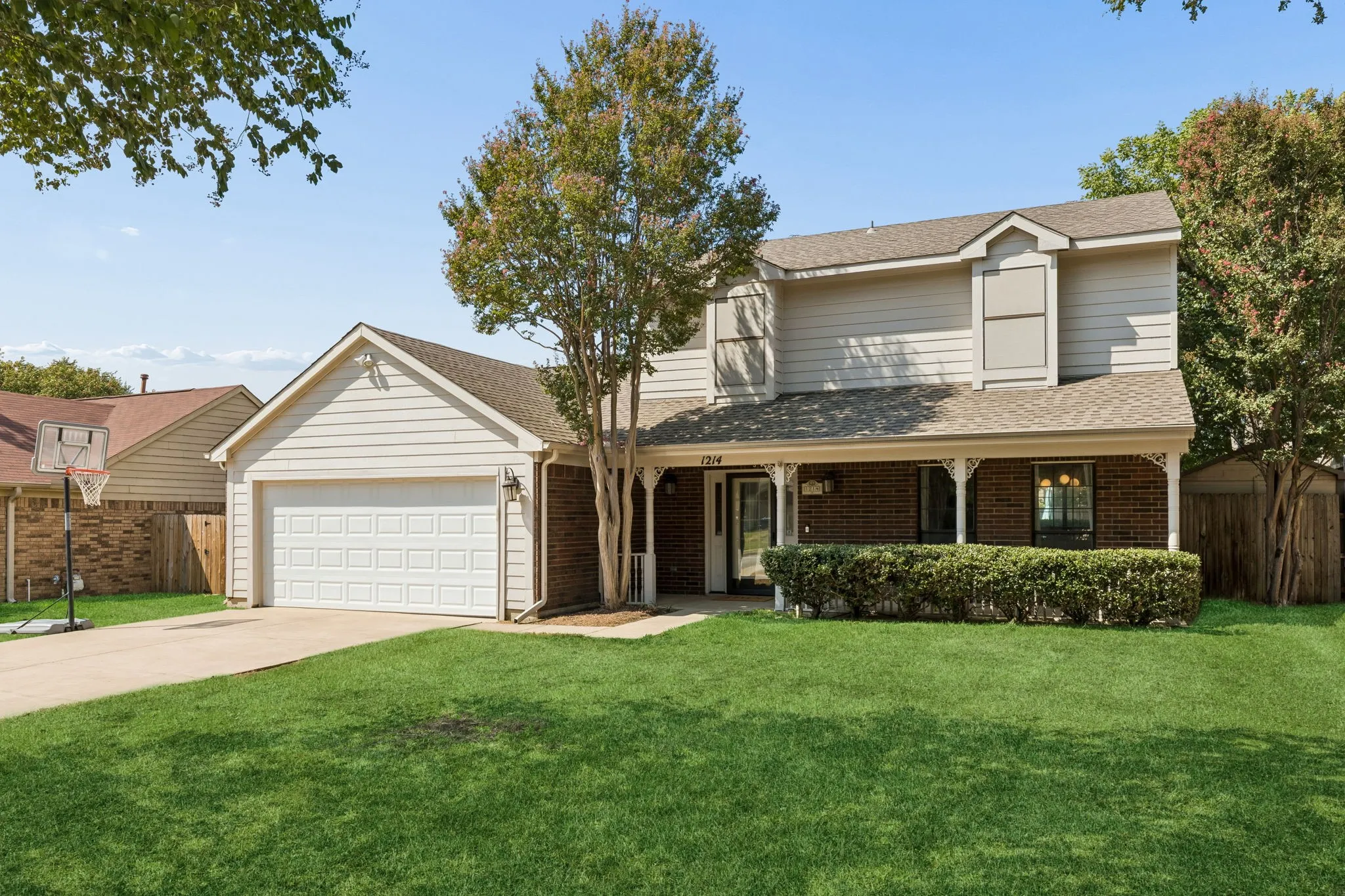 Charming Two-Story Home with Mature Trees, Welcoming Front Porch and Two-Car Garage