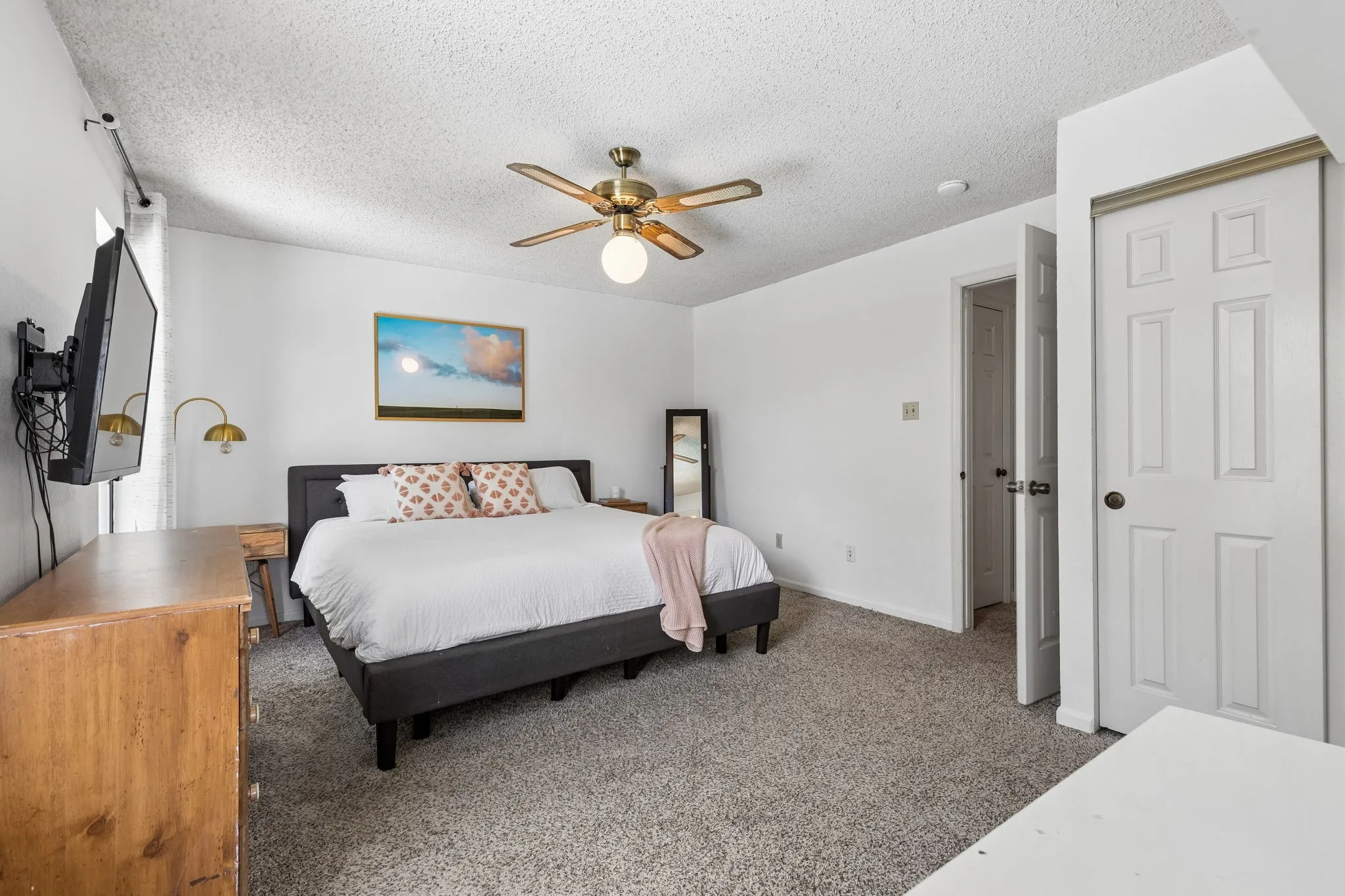 Generously Sized Primary Bedroom with Neutral Finishes, Ceiling Fan and Convenient Ensuite Access