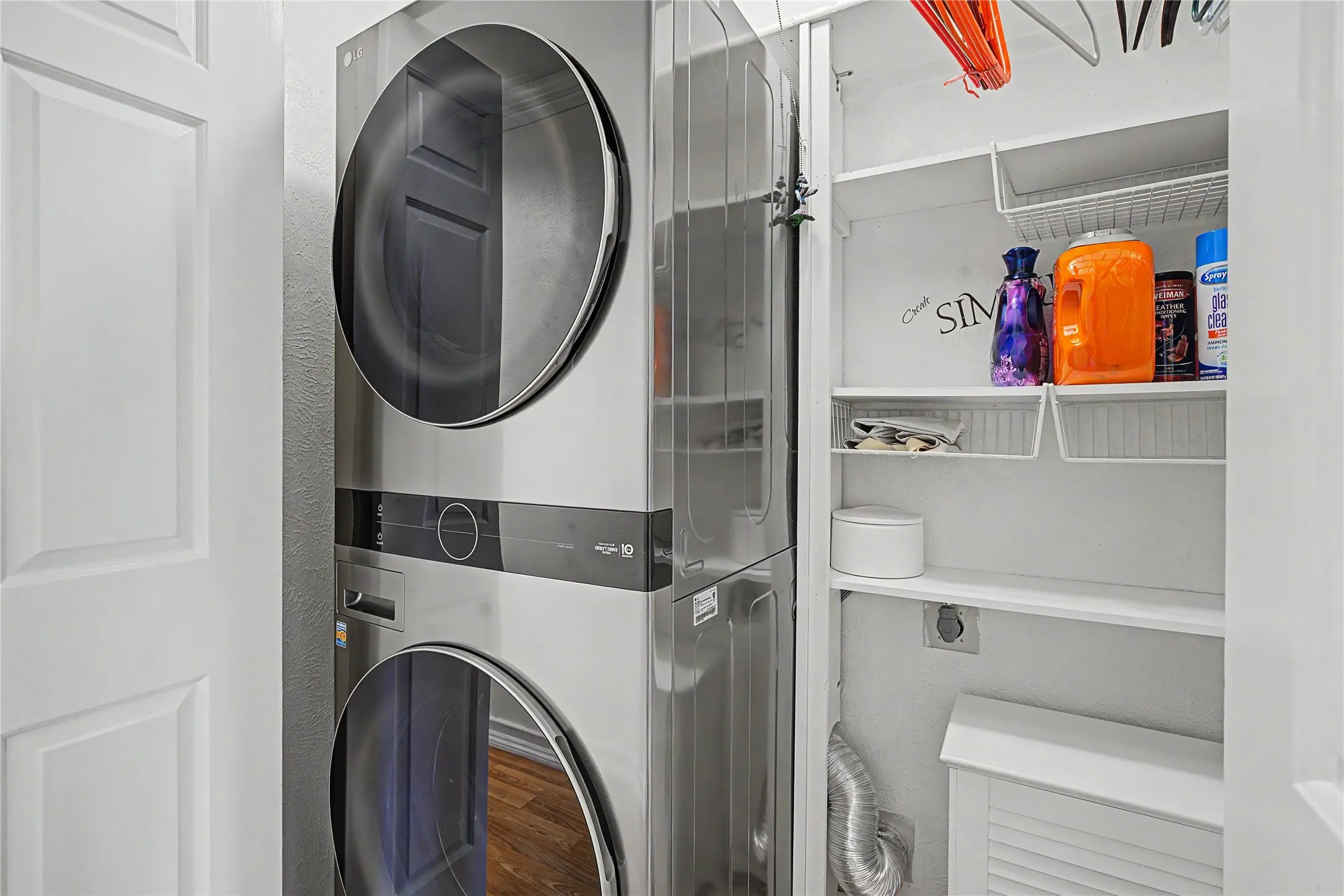 Integrated laundry center with a stainless steel finish and internal shelving