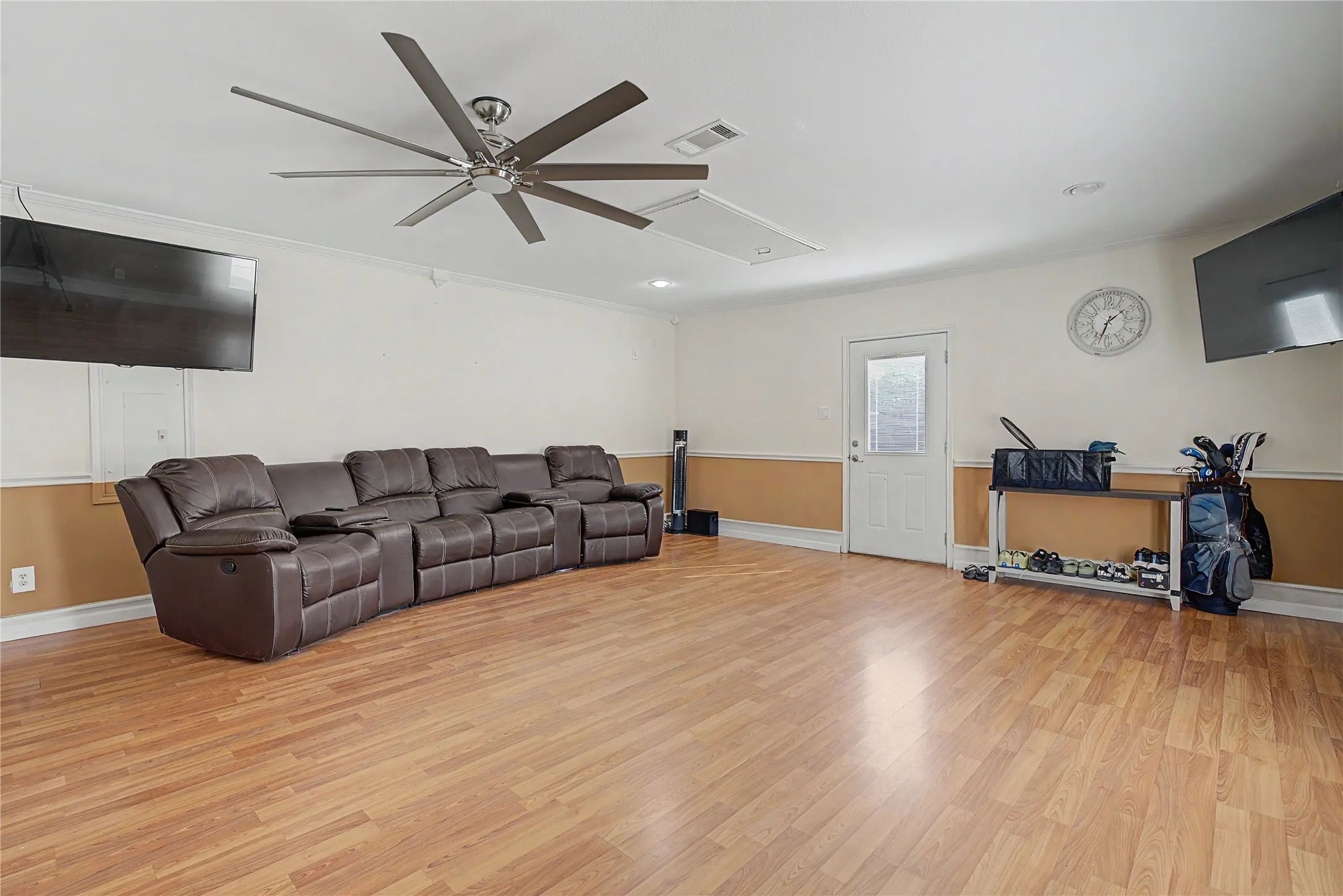 Spacious room featuring wood-finish flooring, a large ceiling fan, and recessed lighting