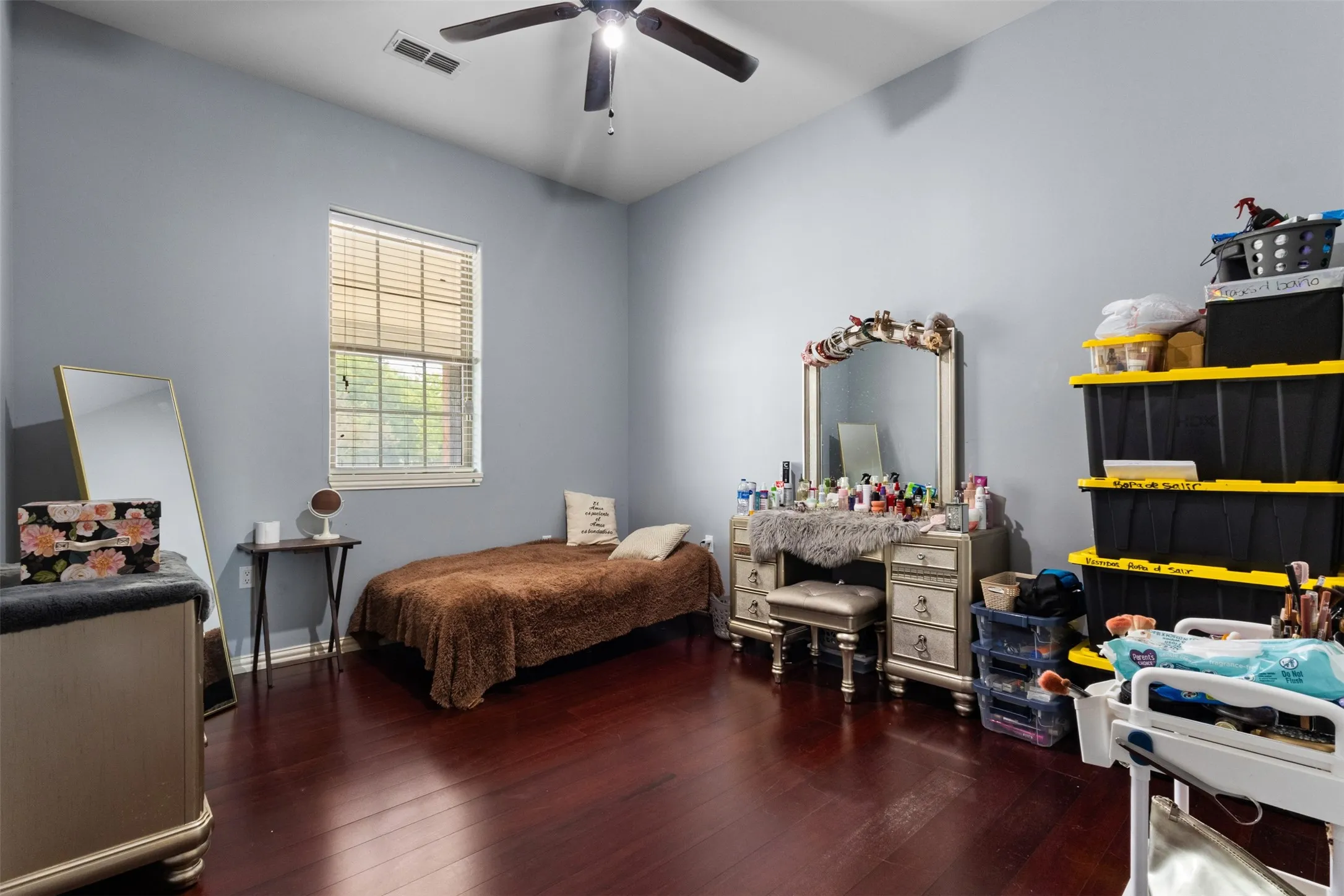 High ceilings, rich wood-finish flooring, and a ceiling fan