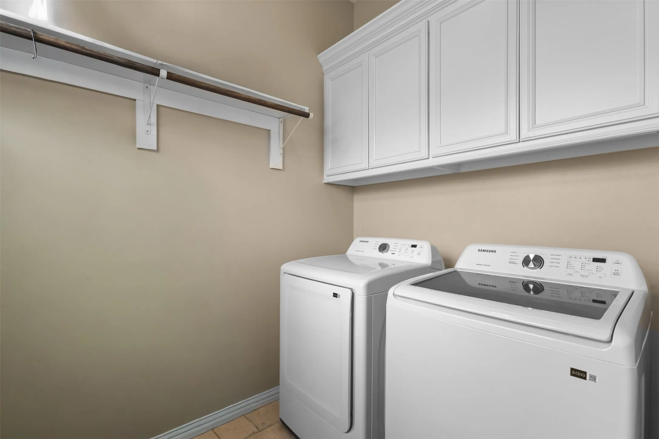White shaker-style cabinetry, crown molding, and a built-in hanging rod