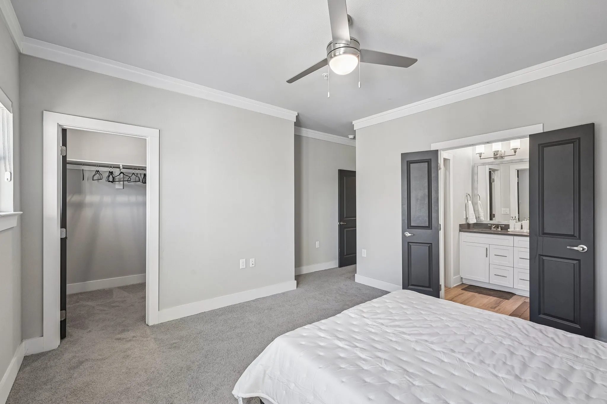 Recessed lighting, wood-finish flooring, ceiling fan with integrated light, built-in closet with hanging rod, and white vanity with dual sinks