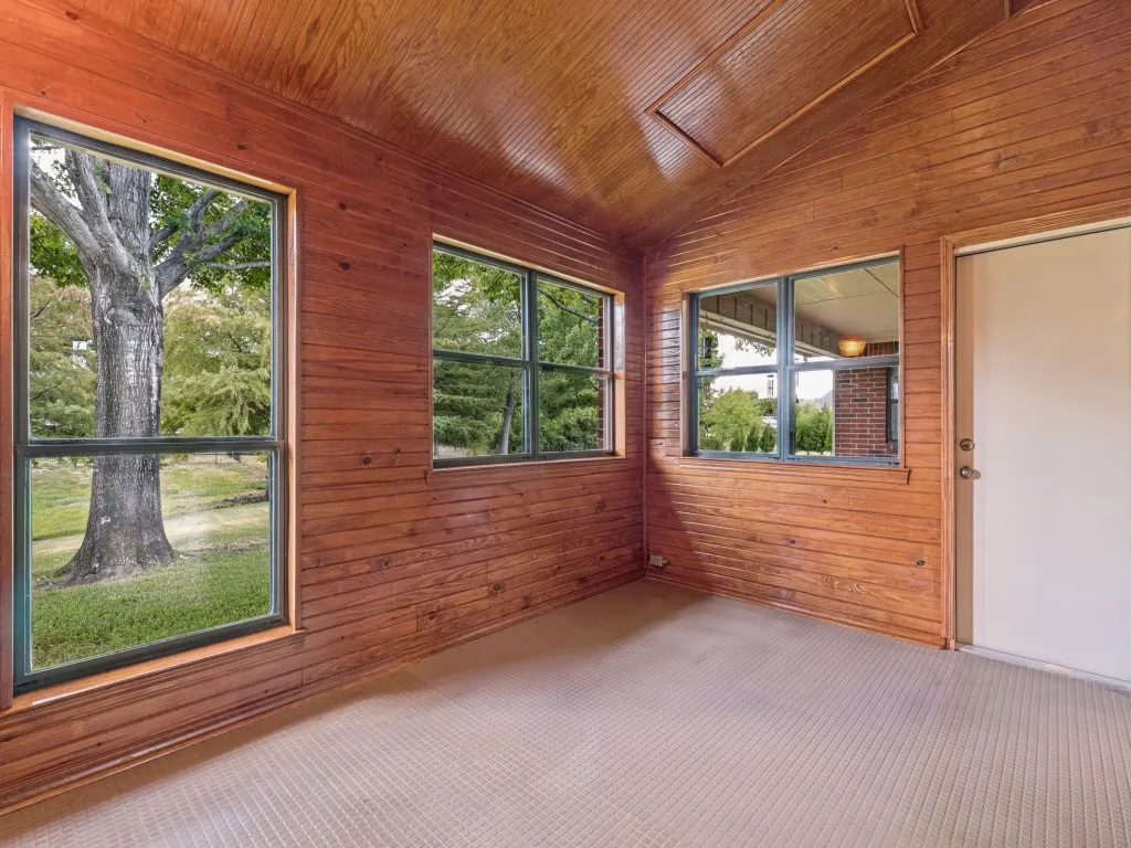 Sunroom with durable flooring, overlooking back yard and pond.