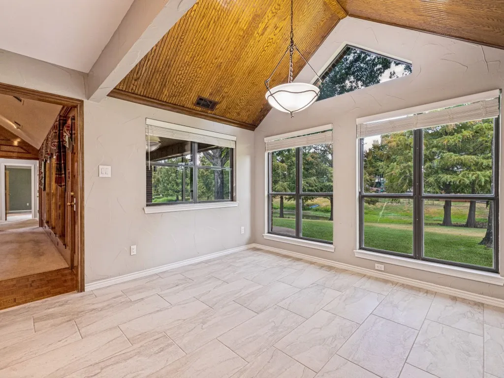 Open dining area with tile, overlooking backyard and pond.