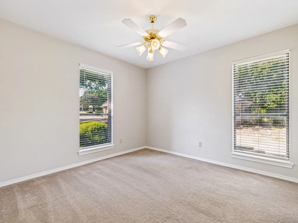 Neutral wall finishes, carpeting, and a ceiling fan with integrated lighting