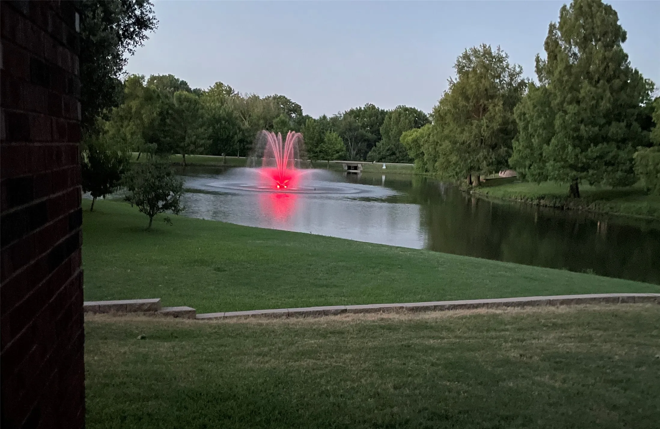 Fountain is lit up at night with varying colors.