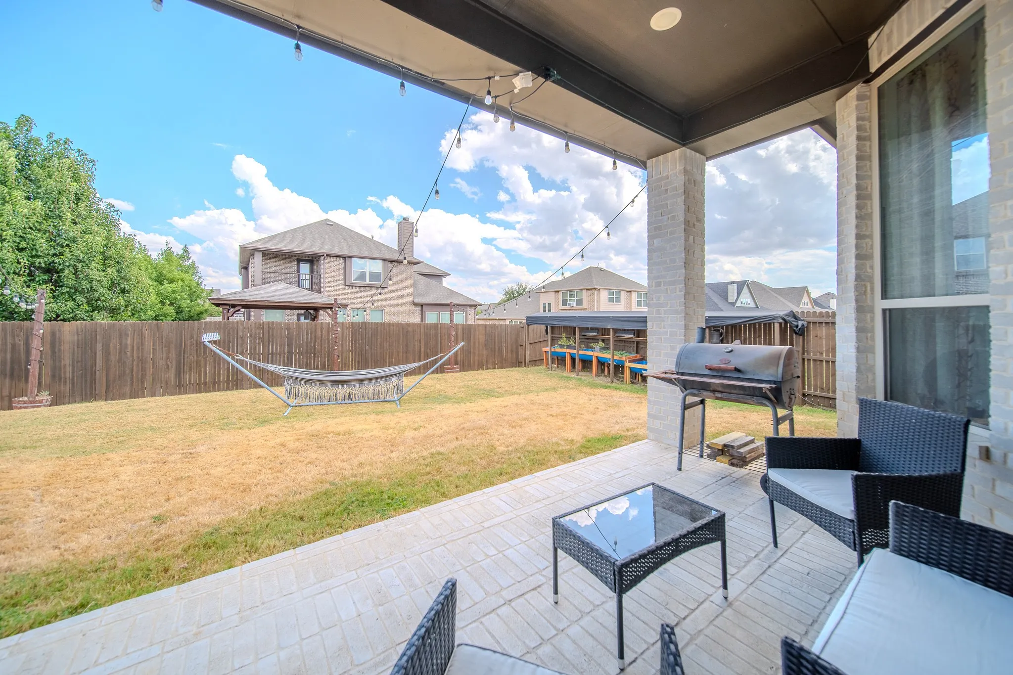 Covered patio featuring a brick-style paver floor, recessed lighting, and string lighting