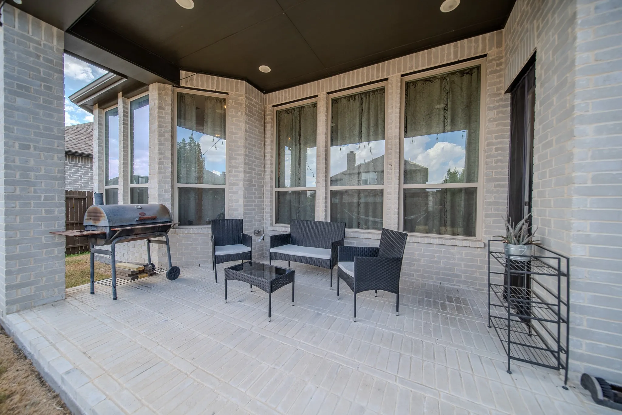 Covered patio with a dark ceiling and recessed lighting