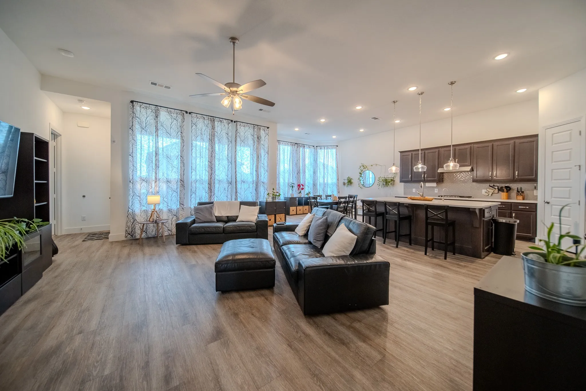 Open-concept living space featuring wood-finish flooring, recessed lighting, and a ceiling fan