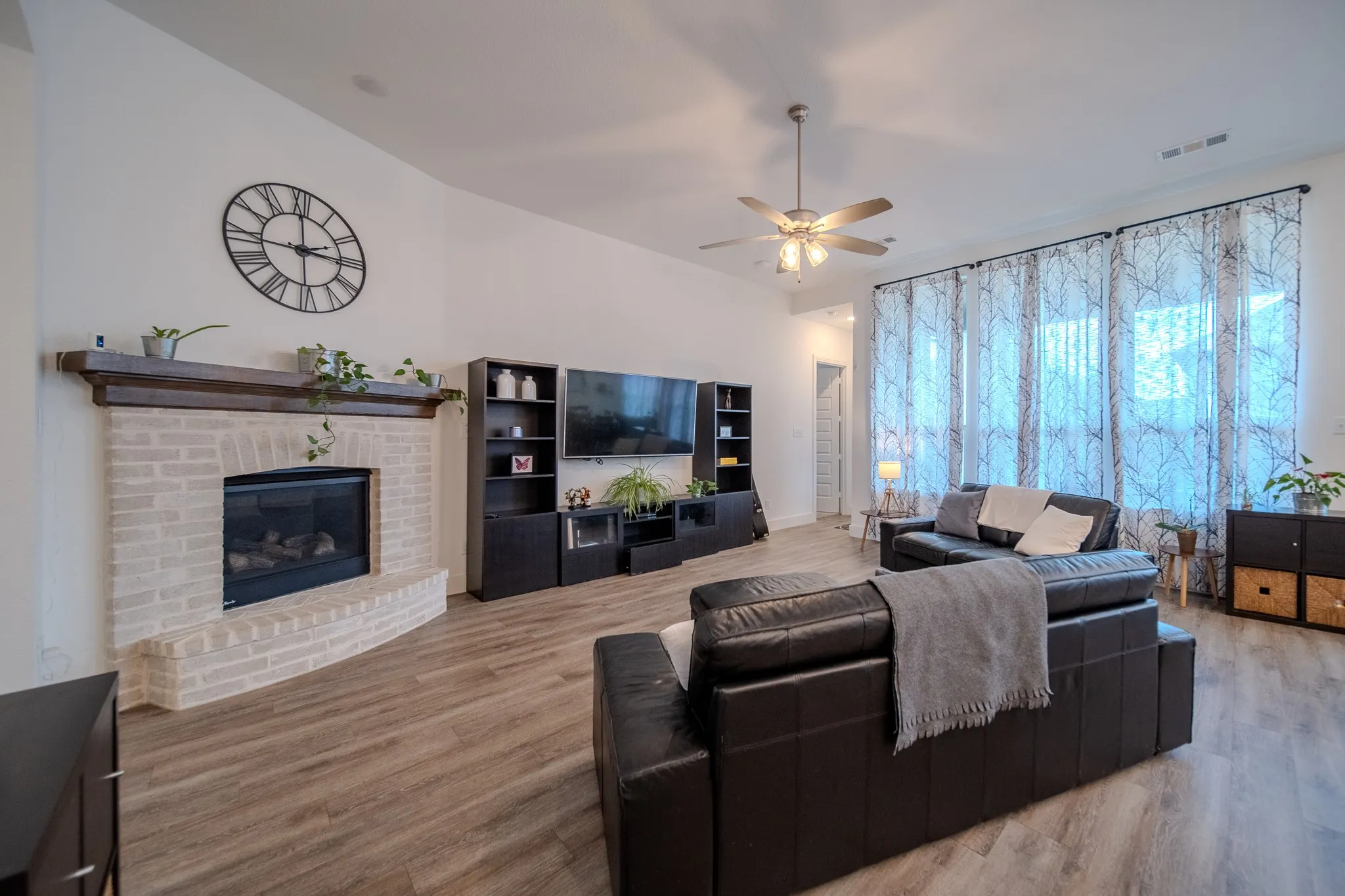 White brick fireplace with a dark wood mantel