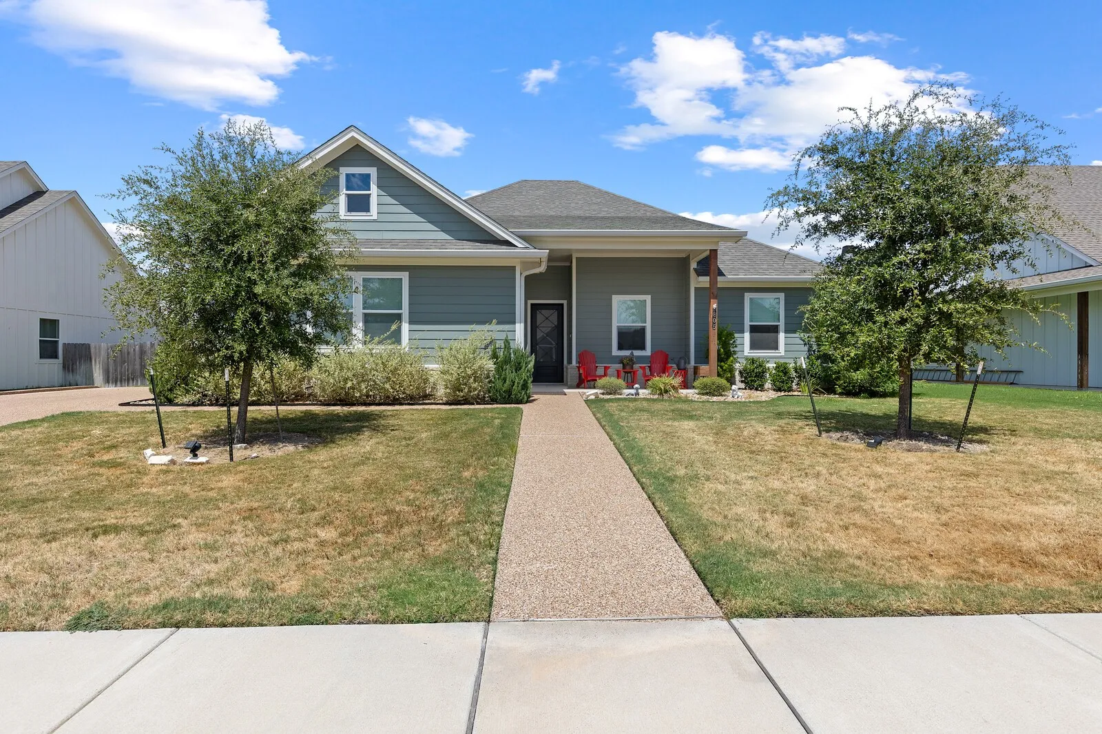 Single-story residence featuring a covered front porch, a gravel-finish walkway, and decorative landscaping