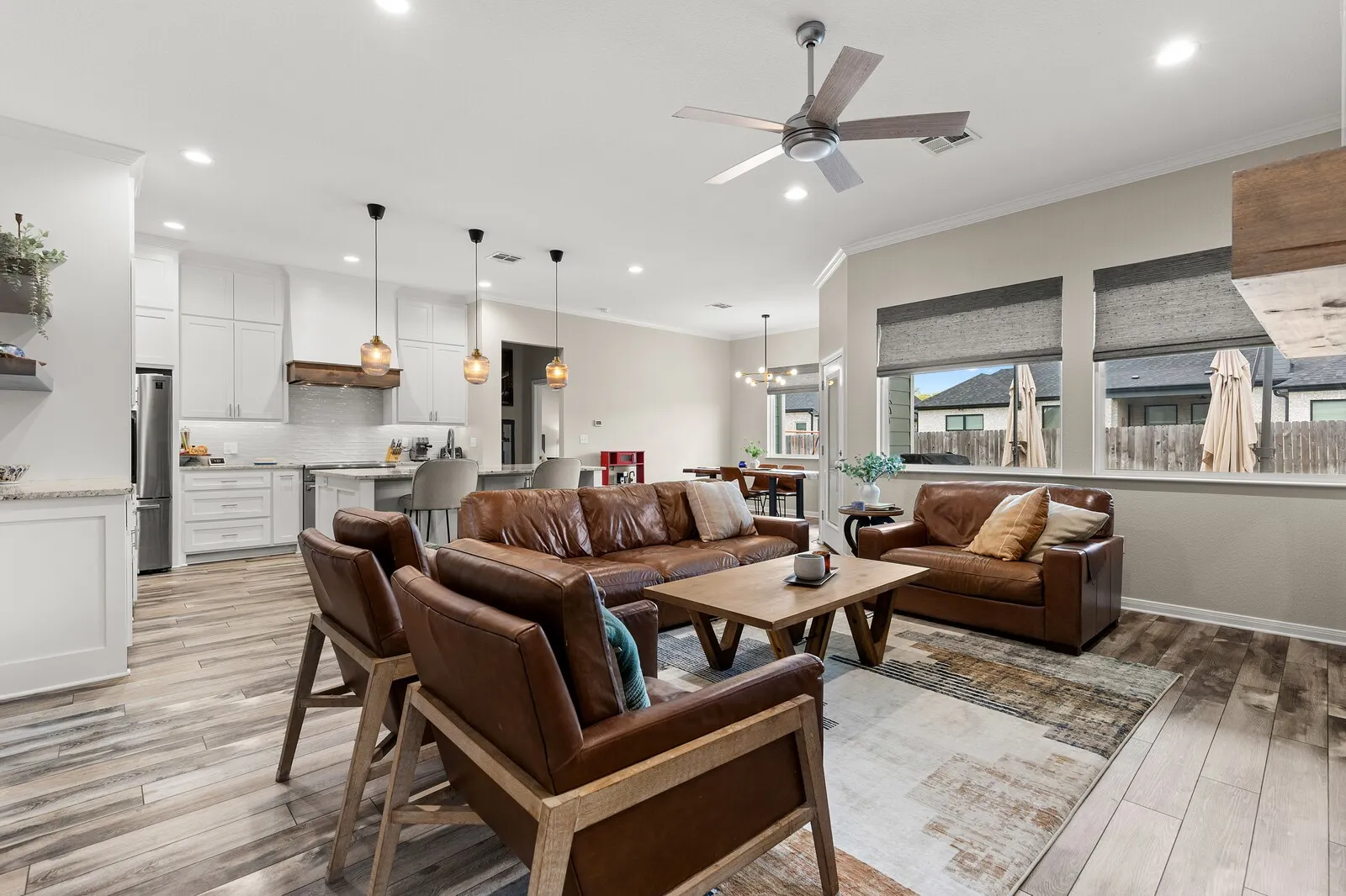 Open-concept living space featuring wood-finish flooring, recessed lighting, and a ceiling fan