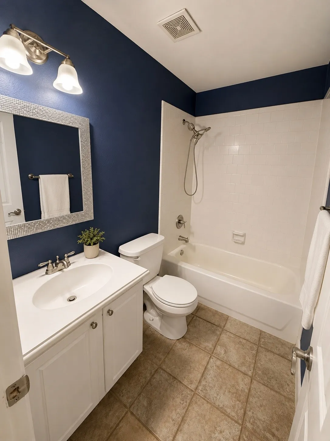 White vanity with a single basin, brushed nickel faucet, and a framed mirror