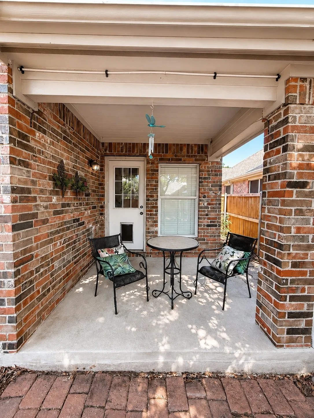 Covered patio featuring brick exterior walls and a concrete surface