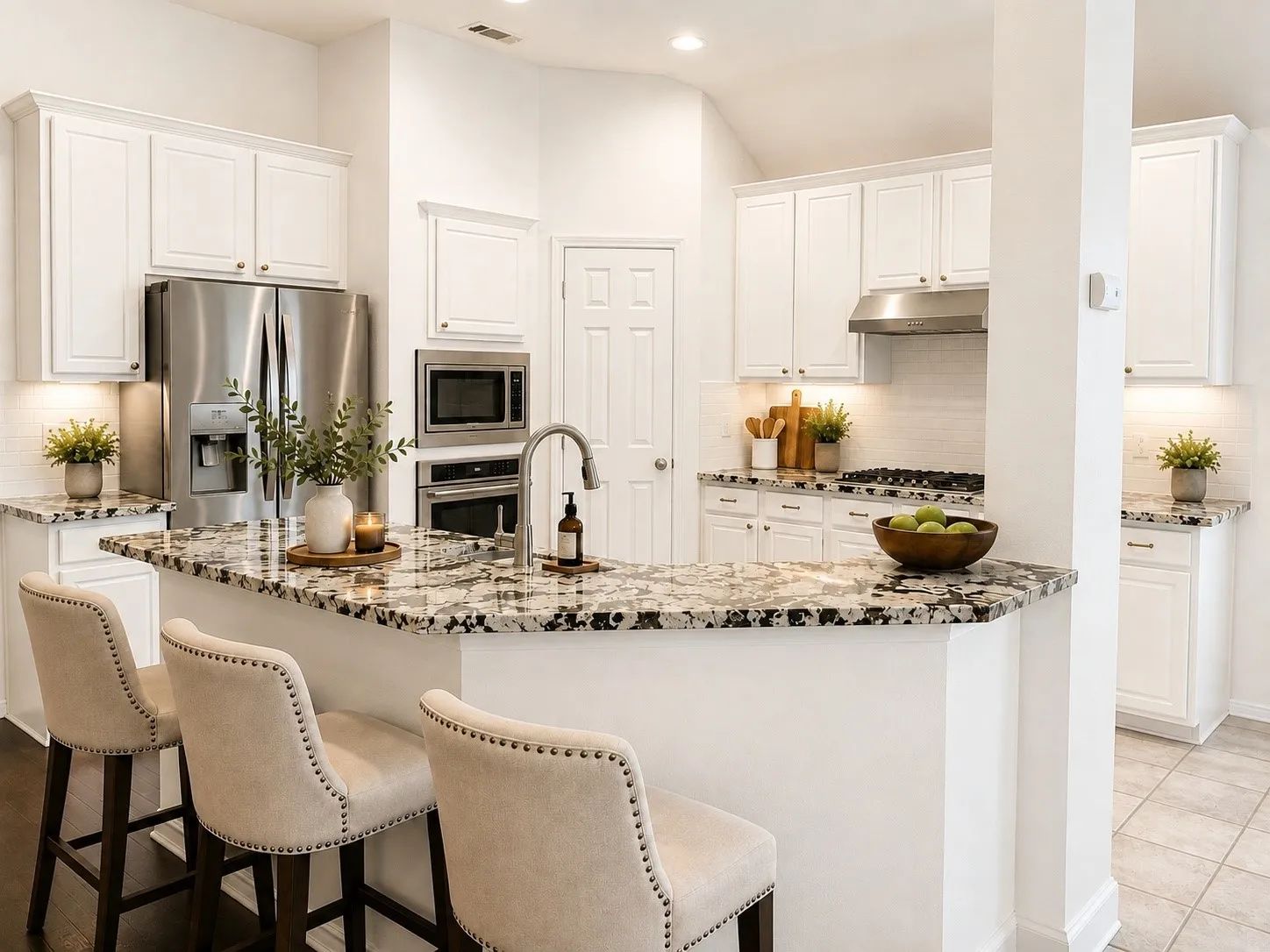 Kitchen featuring white cabinetry, stainless steel appliances, speckled stone countertops, and a subway tile backsplash