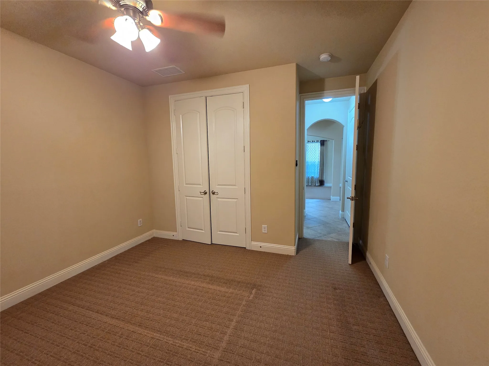 Neutral-toned walls complement the textured carpet flooring