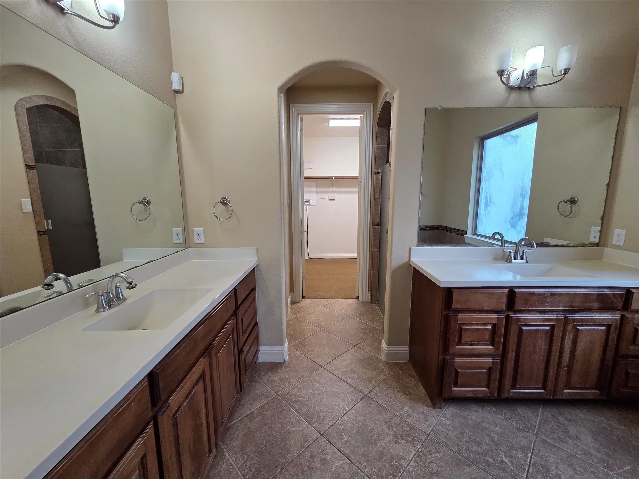 Dual vanity with white countertops and wood cabinetry