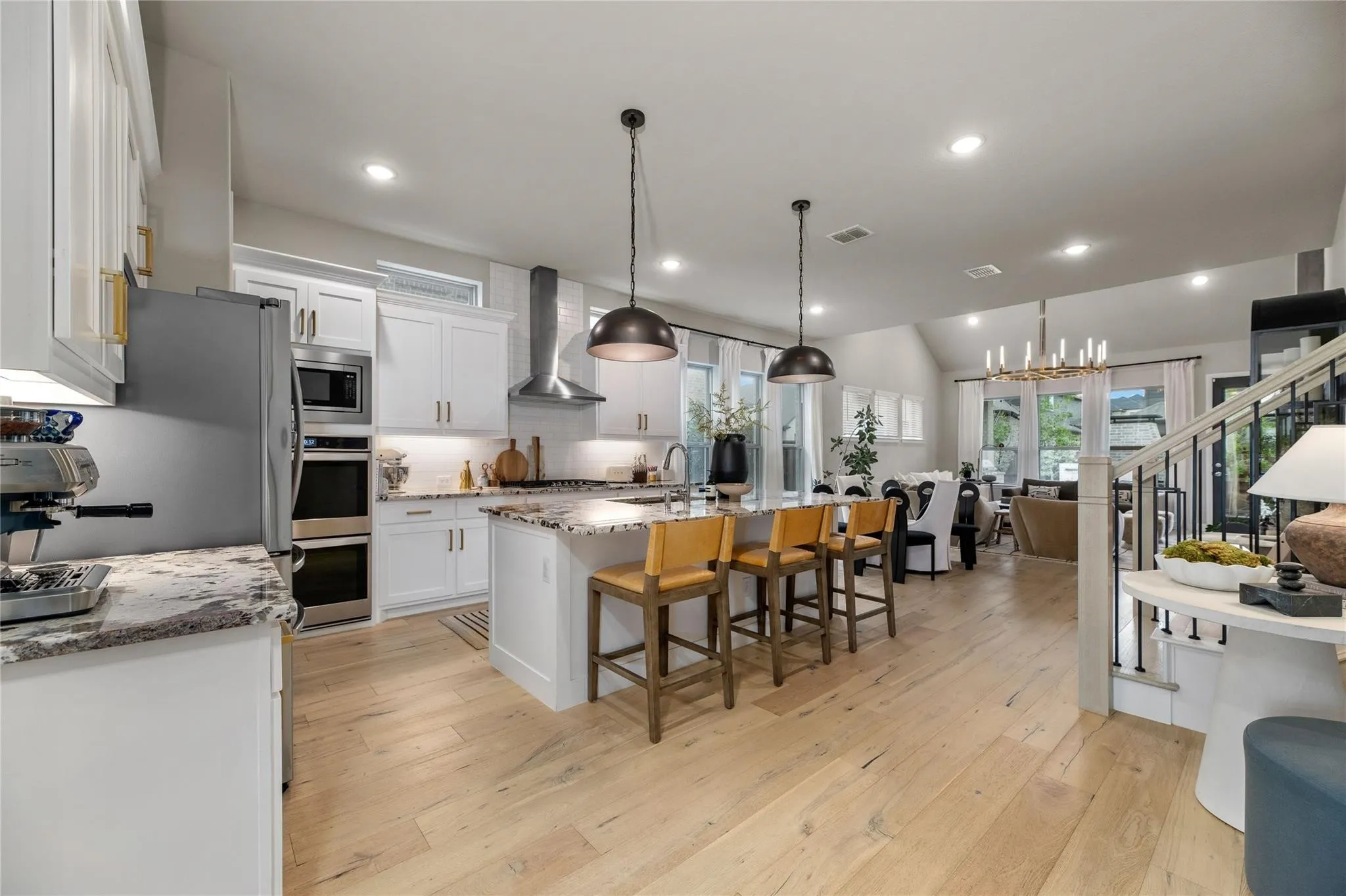 Gourmet kitchen with white cabinetry, stainless steel appliances, and a central island with countertop seating