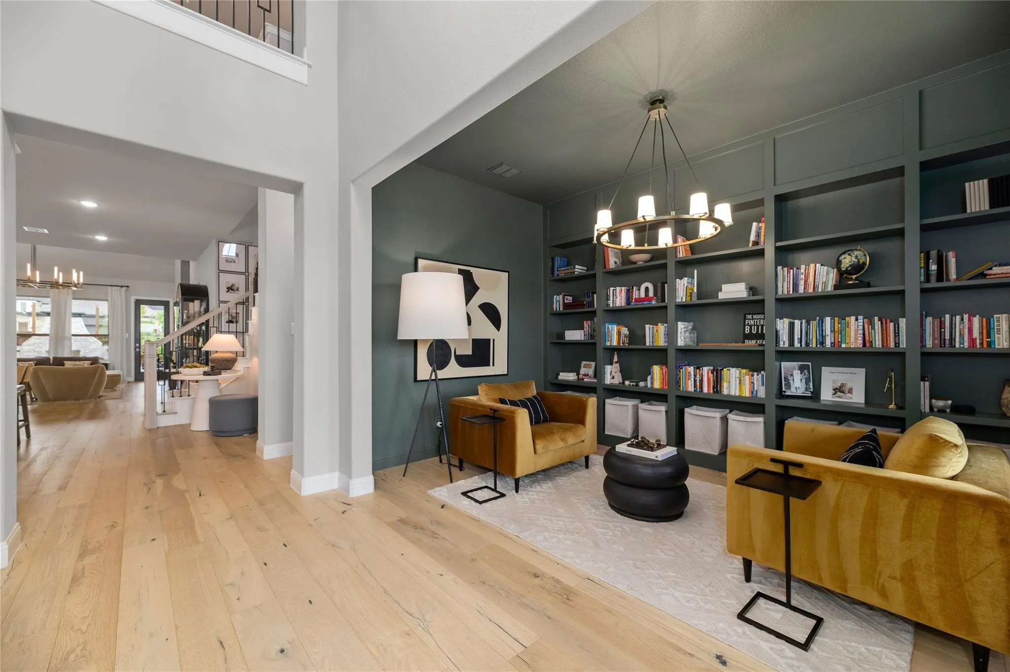 Tall ceilings, wood-finish flooring, built-in shelving, chandelier, and a spacious entryway