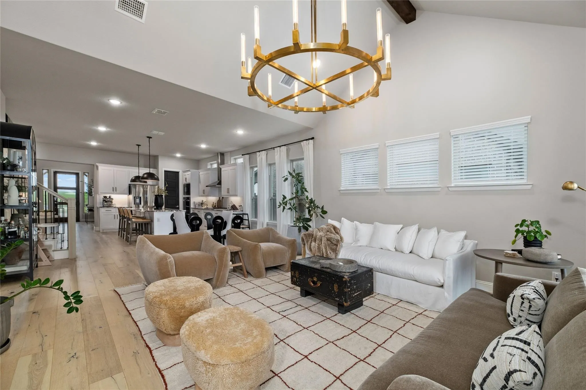Vaulted ceiling, exposed beam, recessed lighting, wood-finish flooring, and a contemporary kitchen with a central island