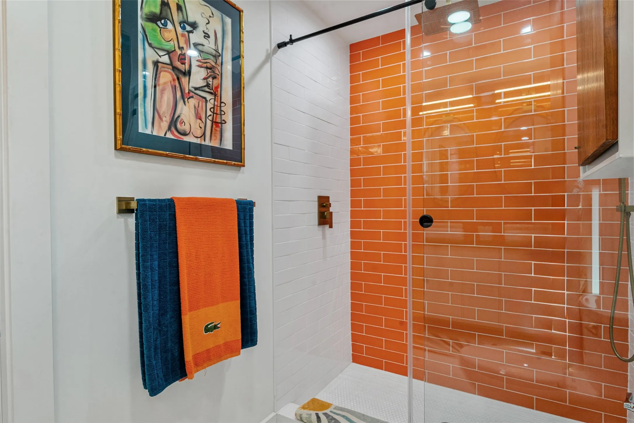 Sliding sleek glass shower door with floor to ceiling tile.