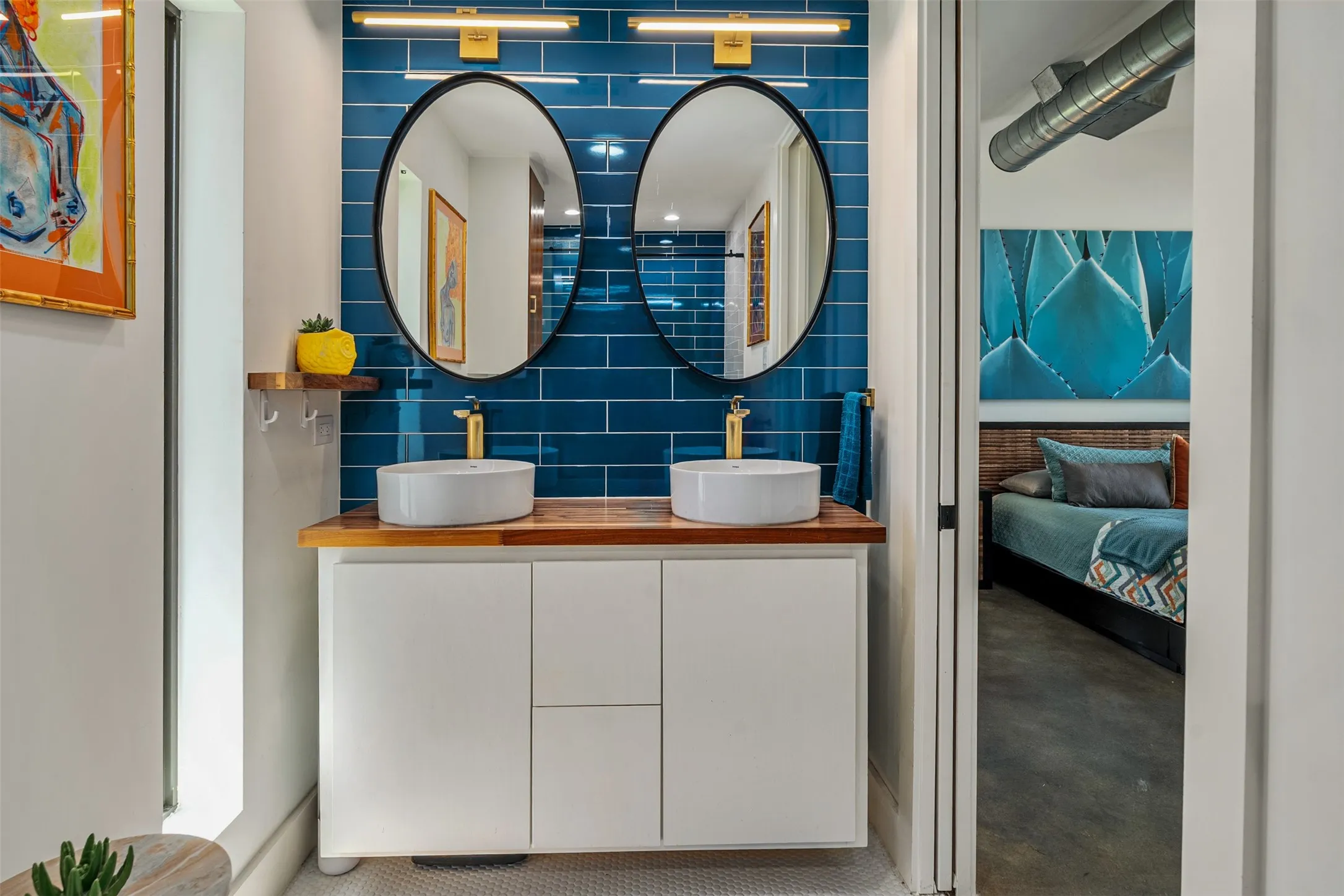 Primary en-Suite bathroom with popping blue tile, double sink and floating cabinet