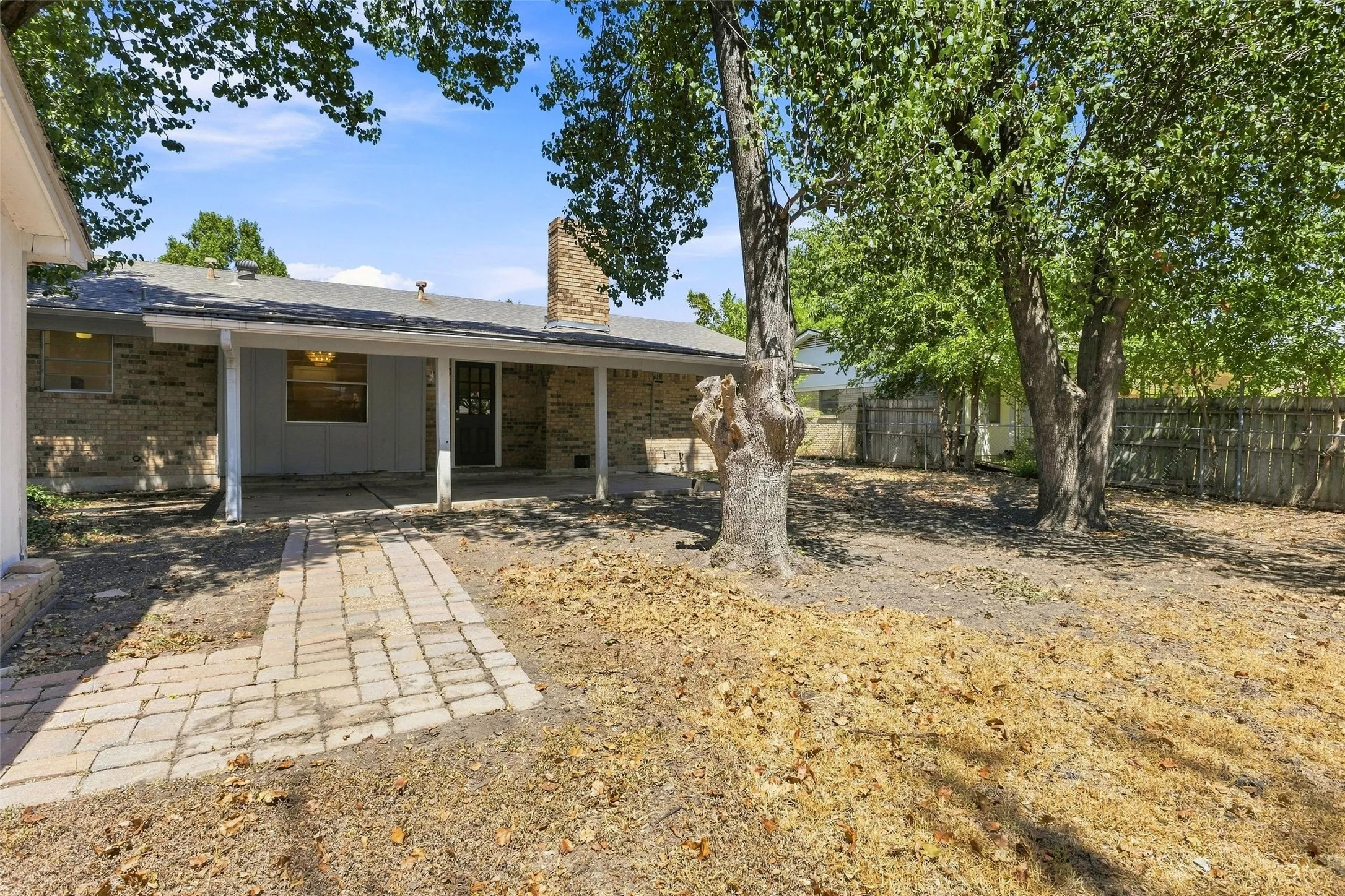 Large backyard with covered porch and storage shed that stays