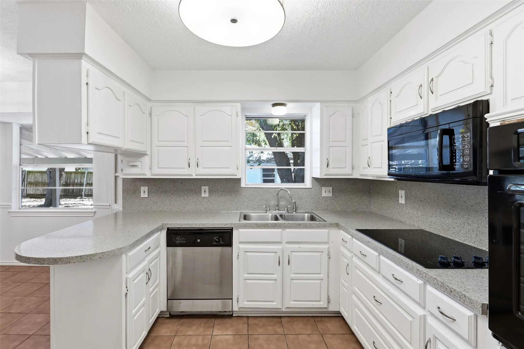 Pretty kitchen with wall oven, electric cooktop, built-in microwave, and so many cabinets