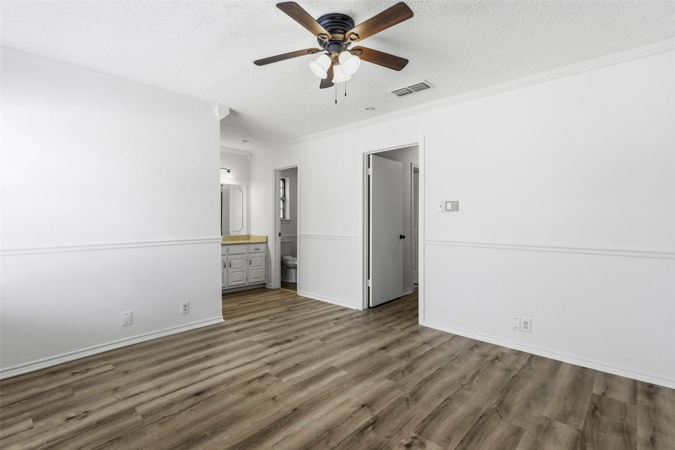 The primary bedroom has pretty flooring, vanity and ensuite bathroom with shower