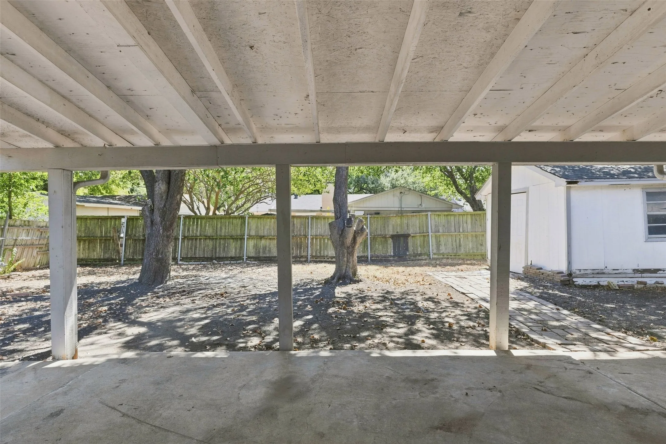Large backyard with covered porch and storage shed that stays