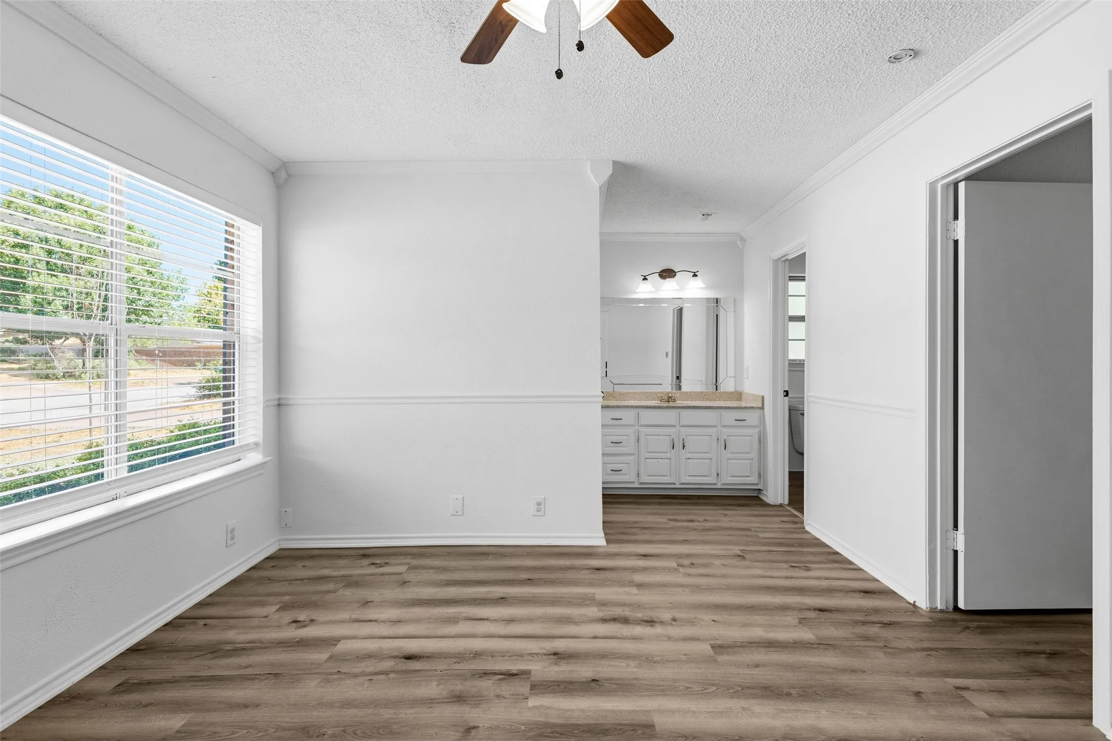The primary bedroom has pretty flooring, vanity and ensuite bathroom with shower
