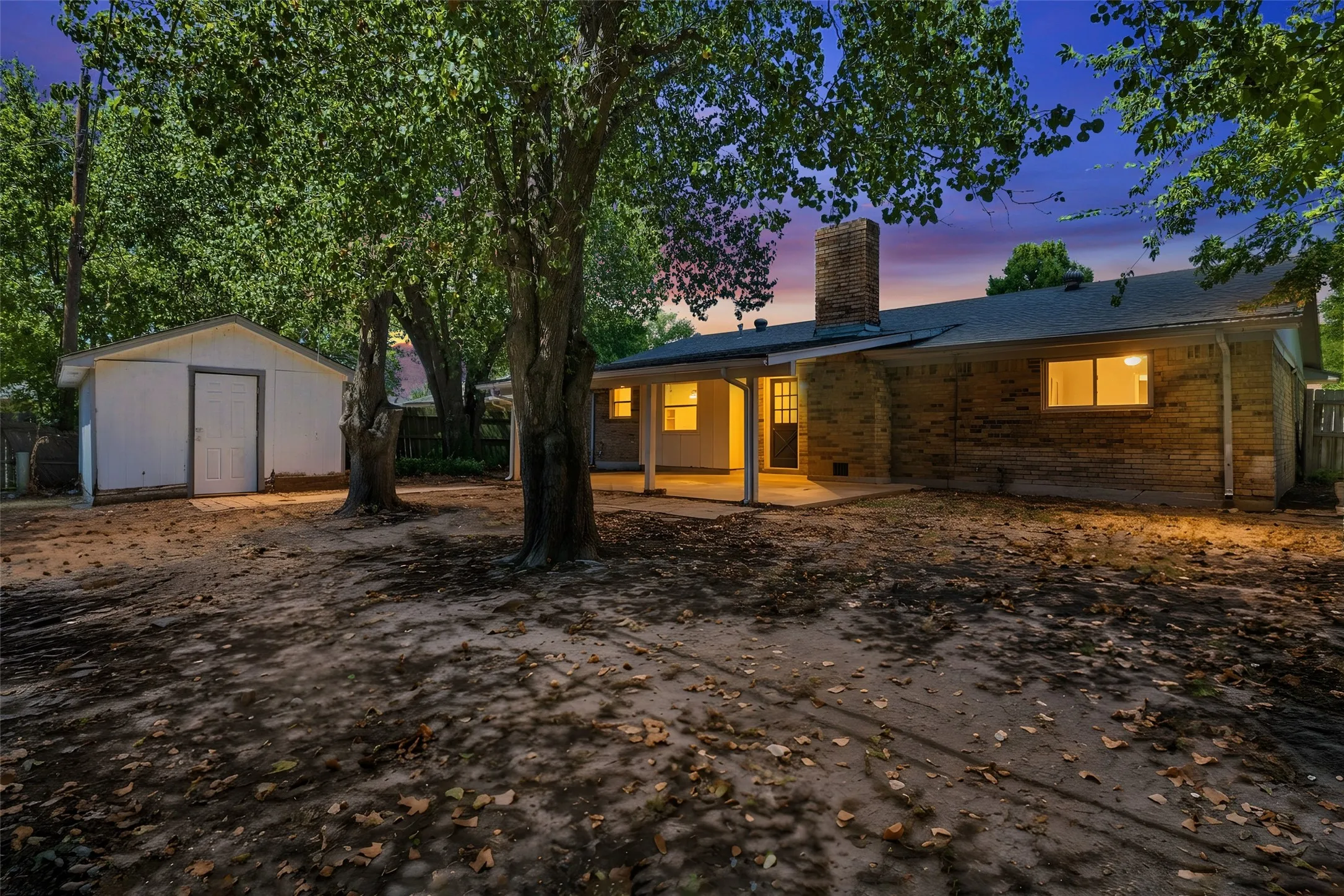 Large backyard with covered porch and storage shed that stays