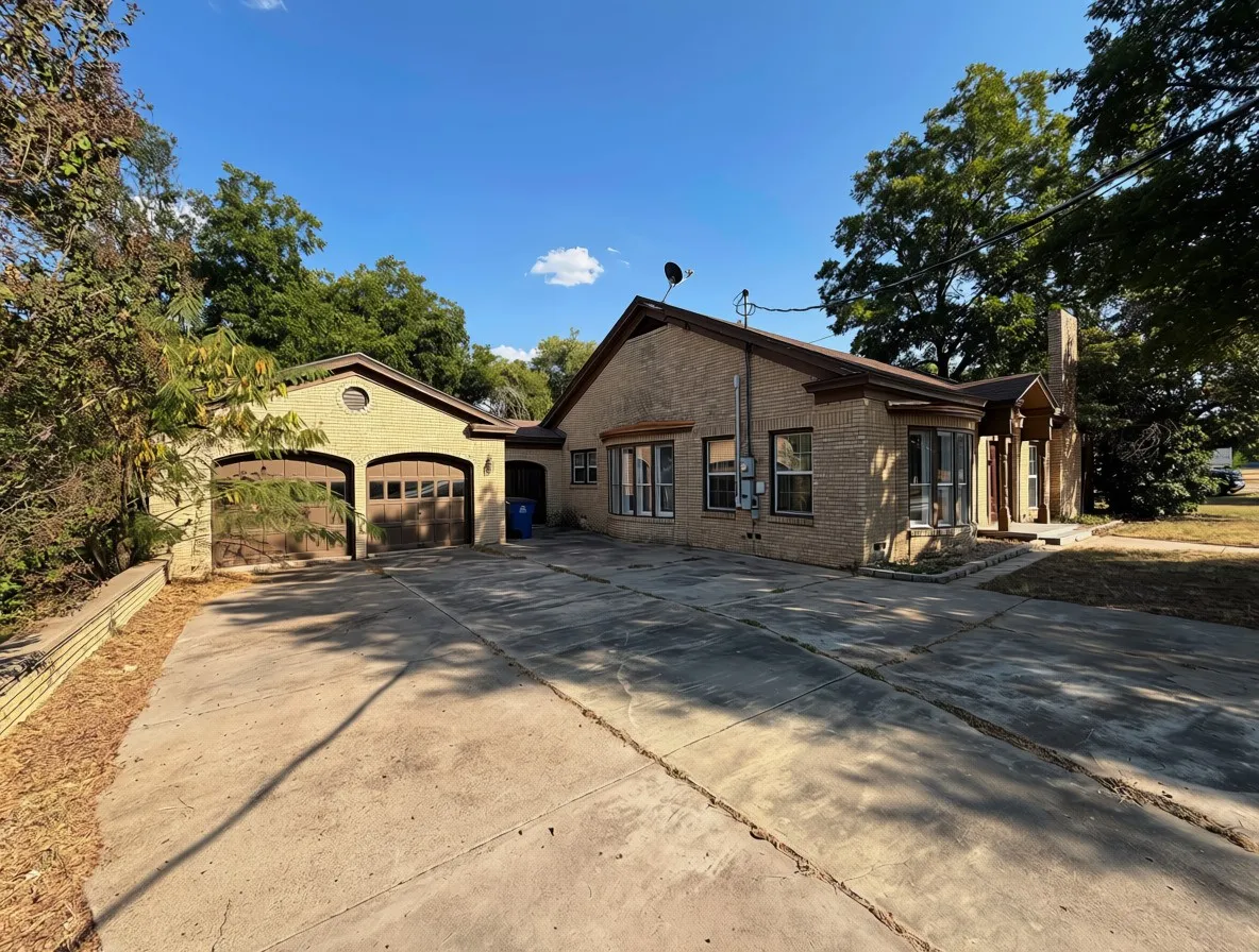 Brick exterior with multiple windows, an attached two-car garage with arched entrances, a concrete driveway, and a covered front entry