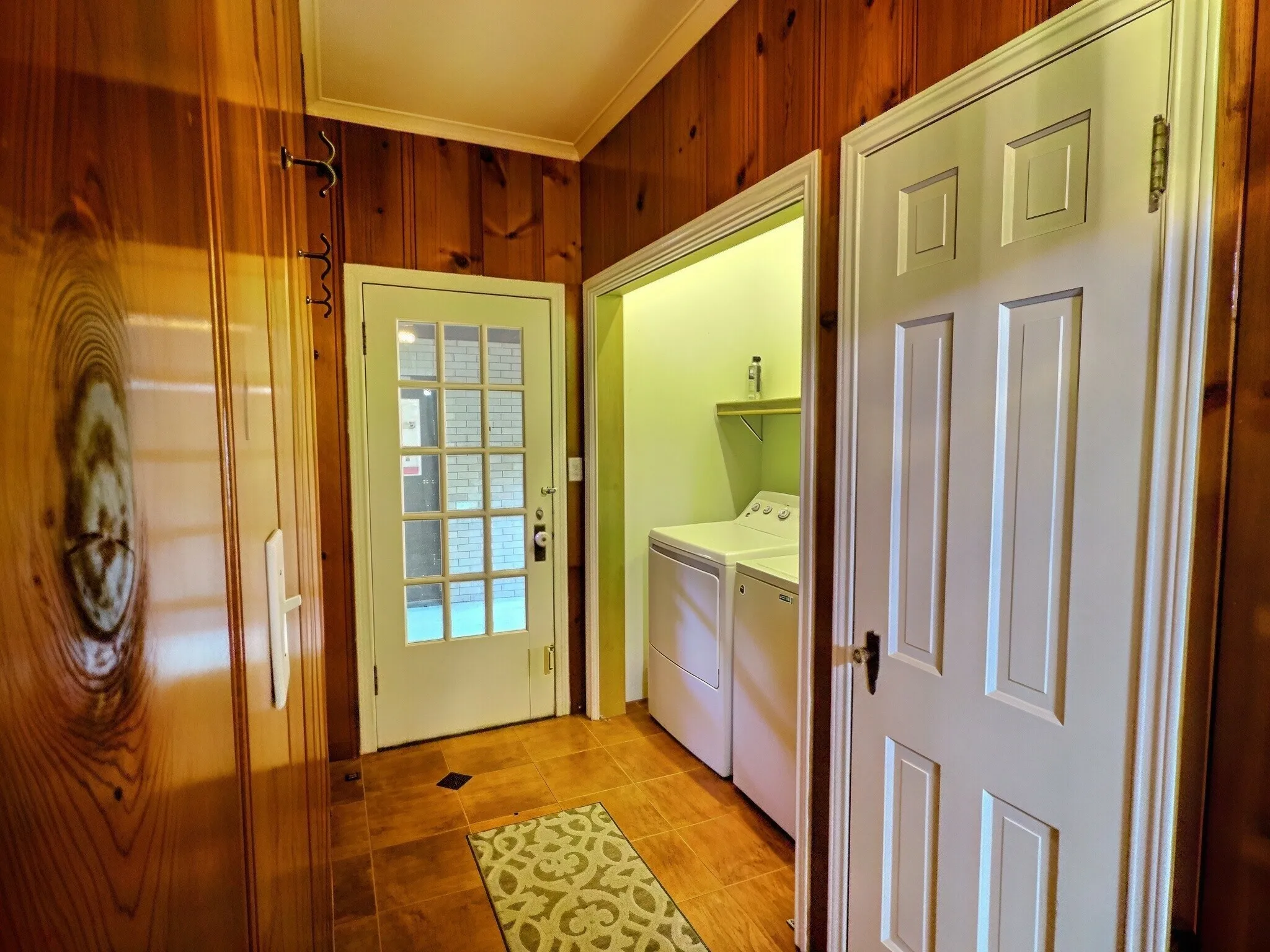 Wood paneling, tile flooring, glass-paneled exterior door, built-in shelving