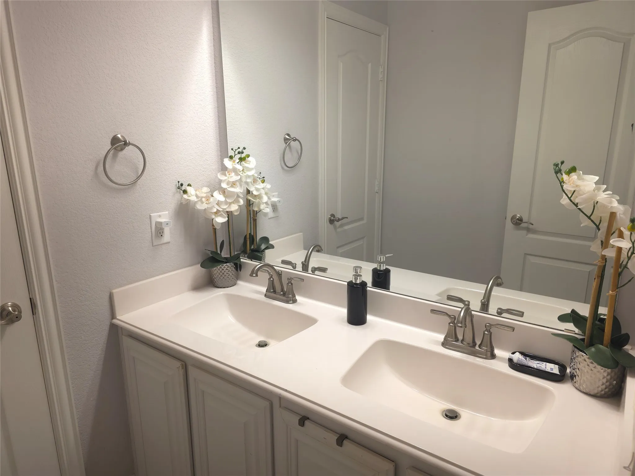 Dual vanity with integrated sinks, white cabinetry, and brushed nickel fixtures