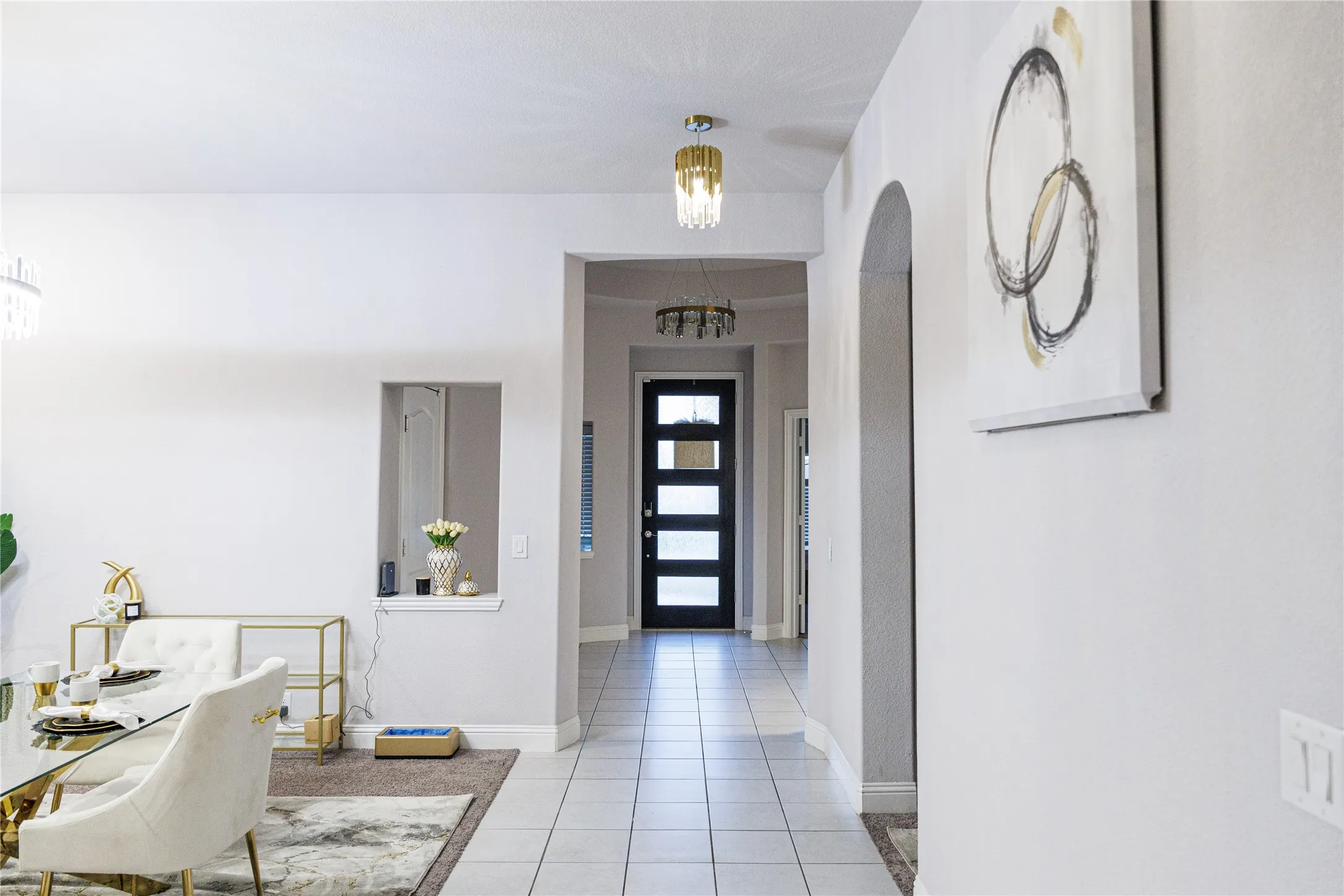 Tile flooring extending through the entry, arched doorway, and built-in wall niche